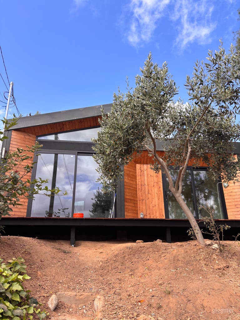  Warm modern exterior with wood cladding, black-framed glass, rooftop railing, clean architectural lines, and bright natural light—ideal for film, TV, photo shoots, commercials, and lifestyle content. 