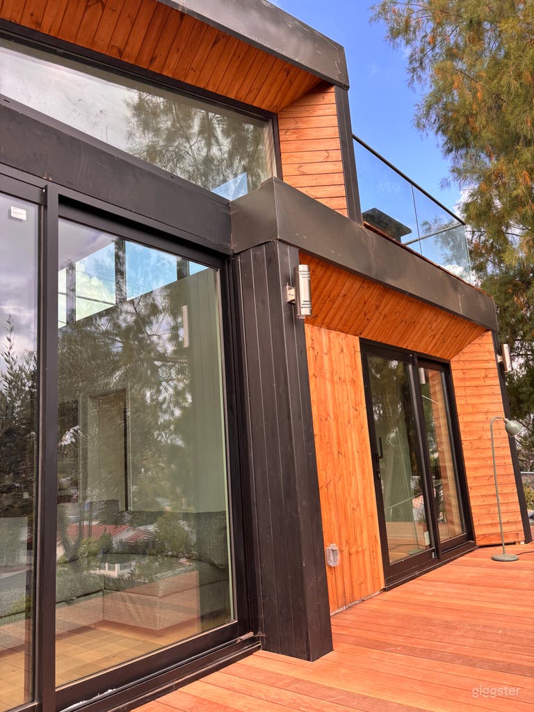  Design-forward exterior with warm wood siding, large windows, mature landscaping, and a sleek modern profile—perfect for film, TV, photo shoots, branded content, and lifestyle productions. 