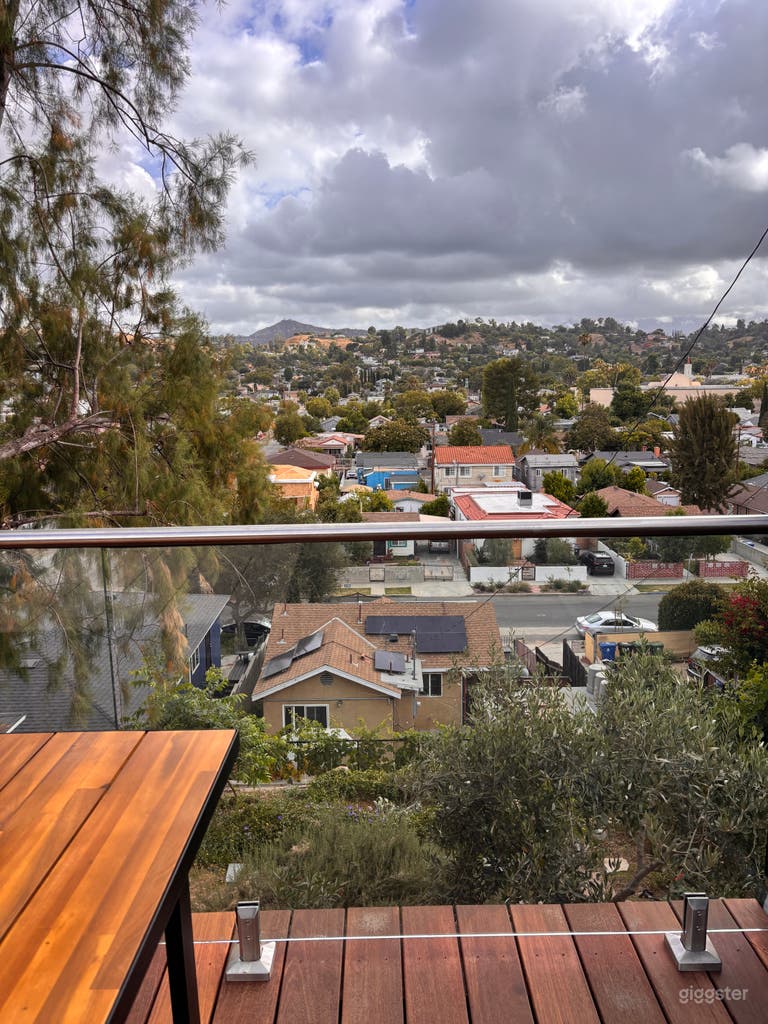  Rooftop deck with glass railing, warm wood decking, lush hillside surroundings, and magnificent Los Angeles views—perfect for exterior scenes, golden-hour photo shoots, lifestyle content, brand campaigns, and intimate creative moments. 