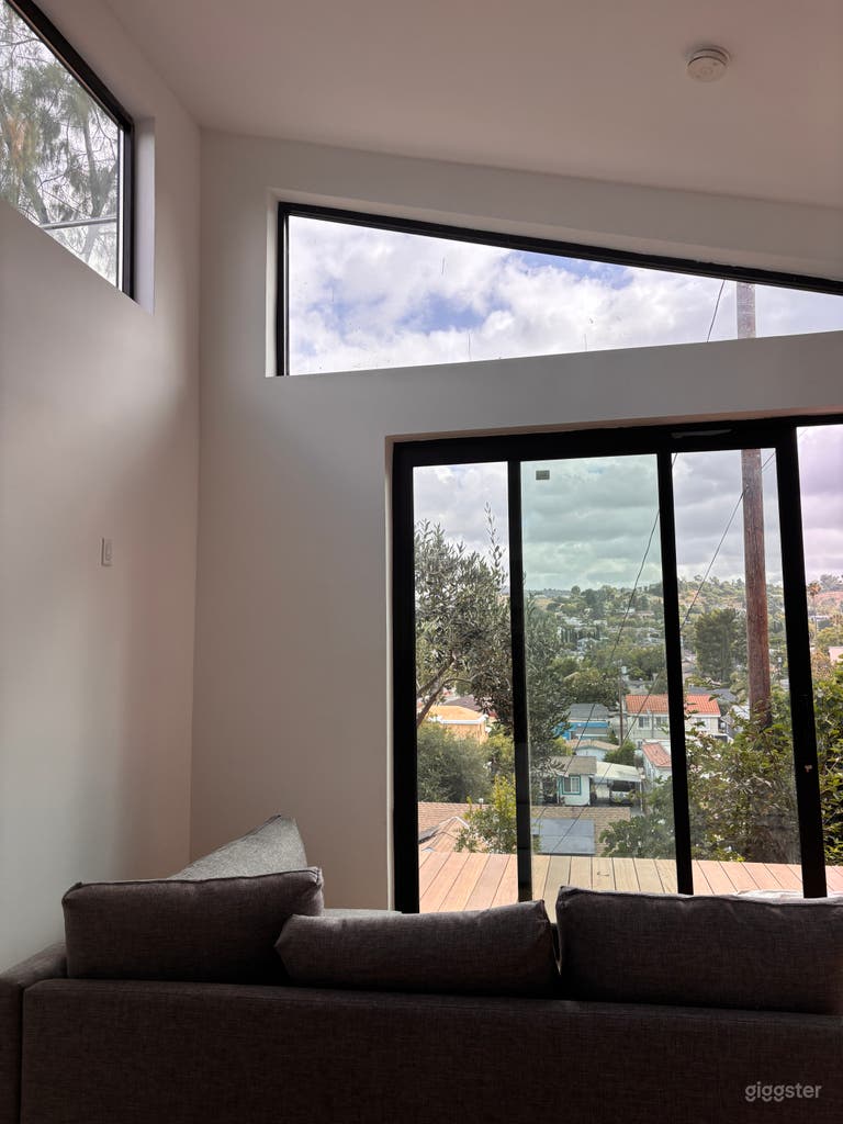  Bright modern interior with soaring ceilings, clerestory windows, dramatic natural light, large sliding glass doors, and expansive hillside views—ideal for film, TV, interviews, lifestyle shoots, and elevated editorial content. 