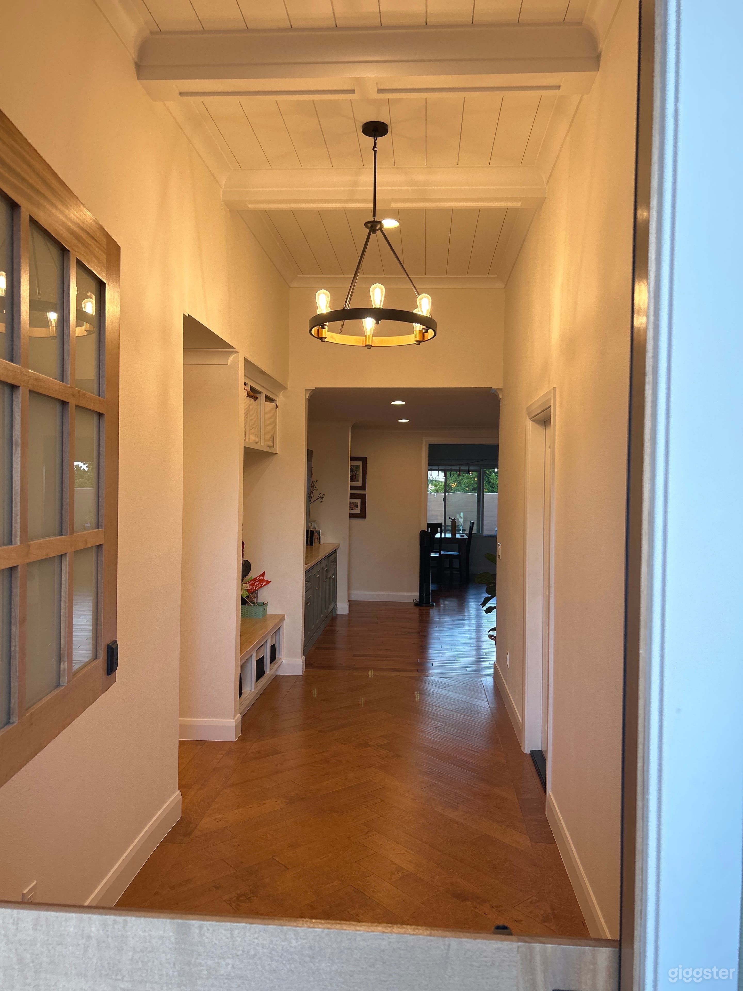Spacious, open and vaulted entry hallway with herringbone wood inlay and oversized dutch door.