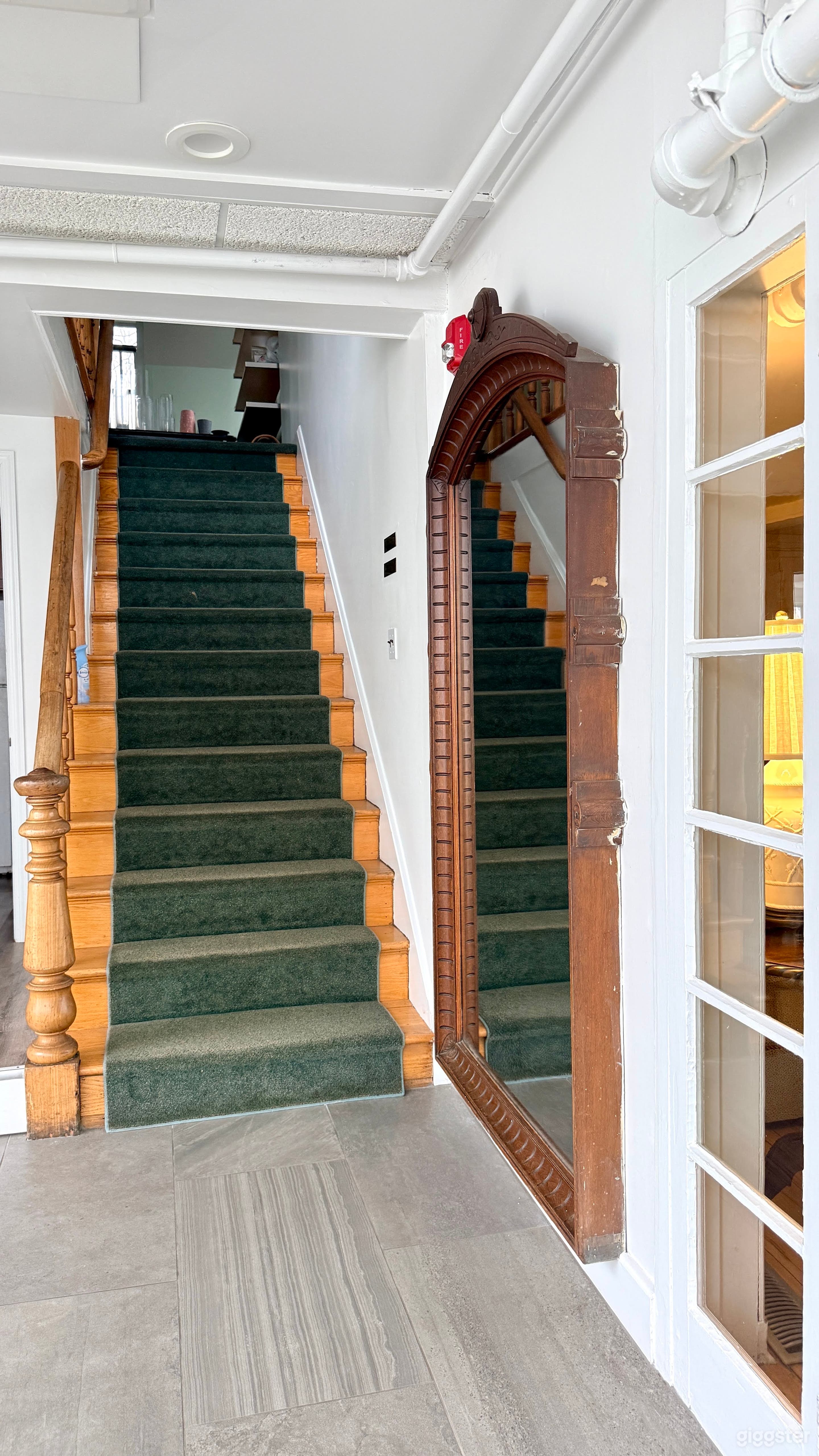 Large mirror on wall (cannot be removed). Stairs leading to second floor.