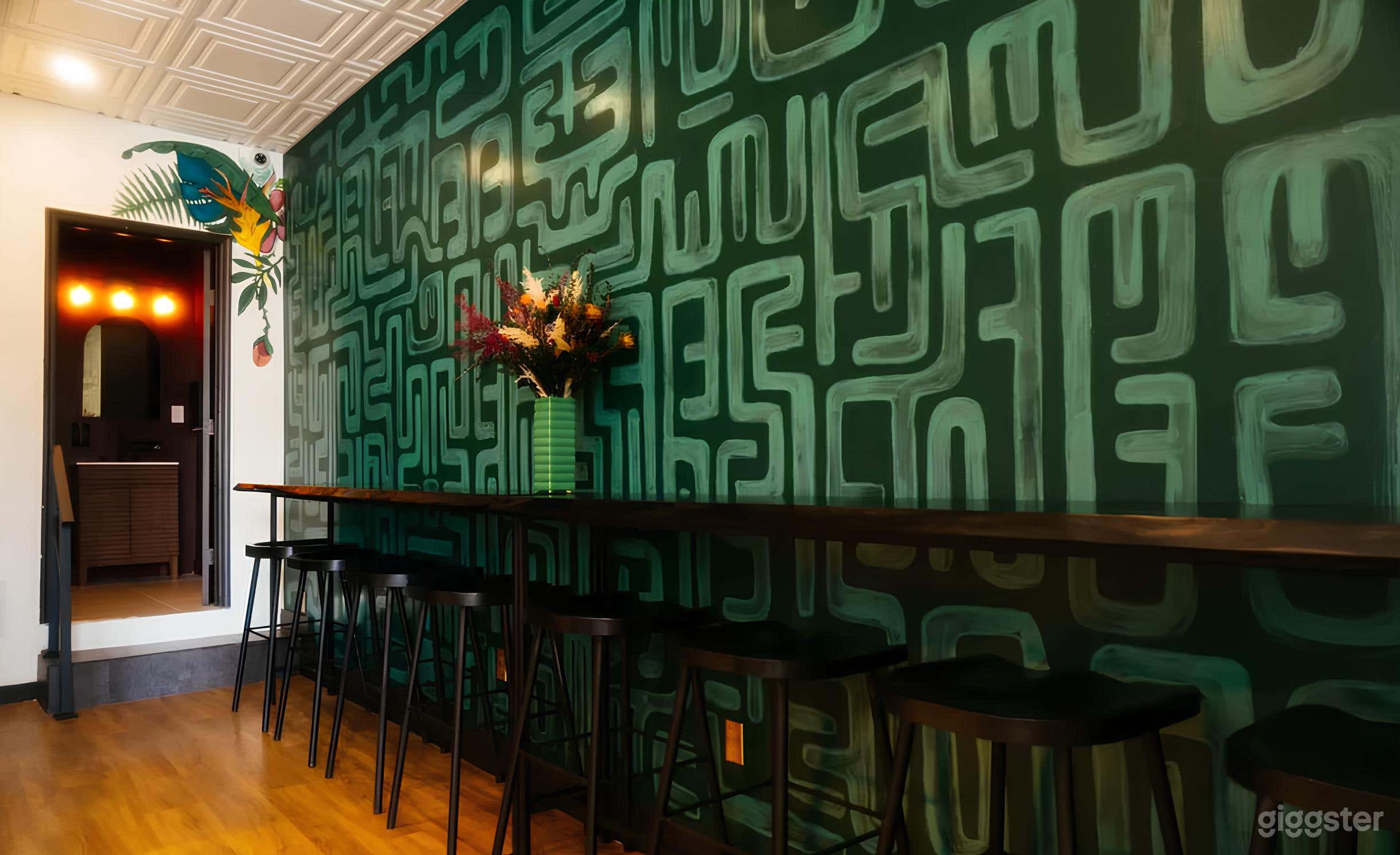 Handcrafted bar tables invite conversation. Bespoke art wall makes a picture-perfect moment. 