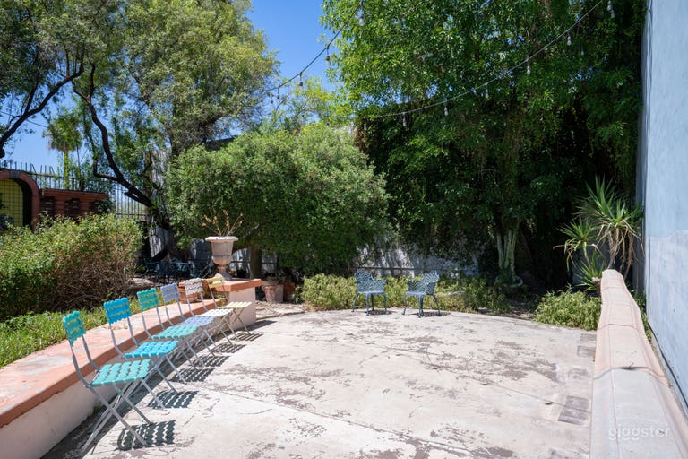  Oasis | Outdoor Studio Space: Lush greenery, rustic accents, stone pathways, string lights, versatile layouts for various shoots. 