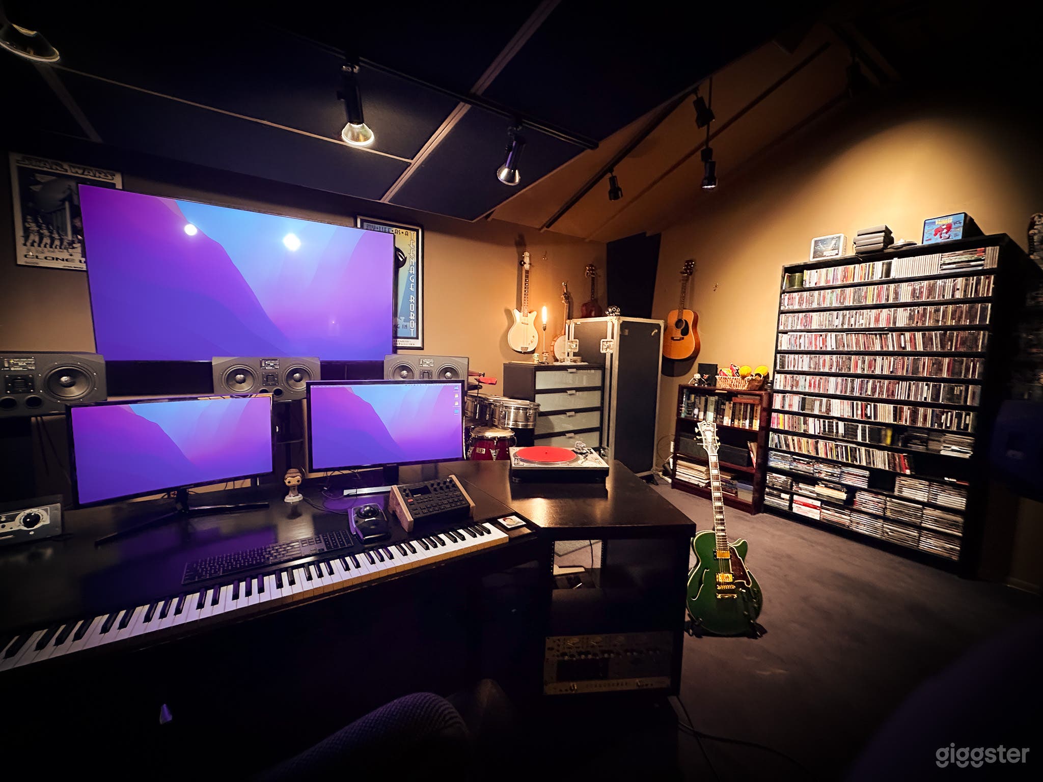 Three monitor setup, including a 70" TV. Midi keyboard and other instruments included.