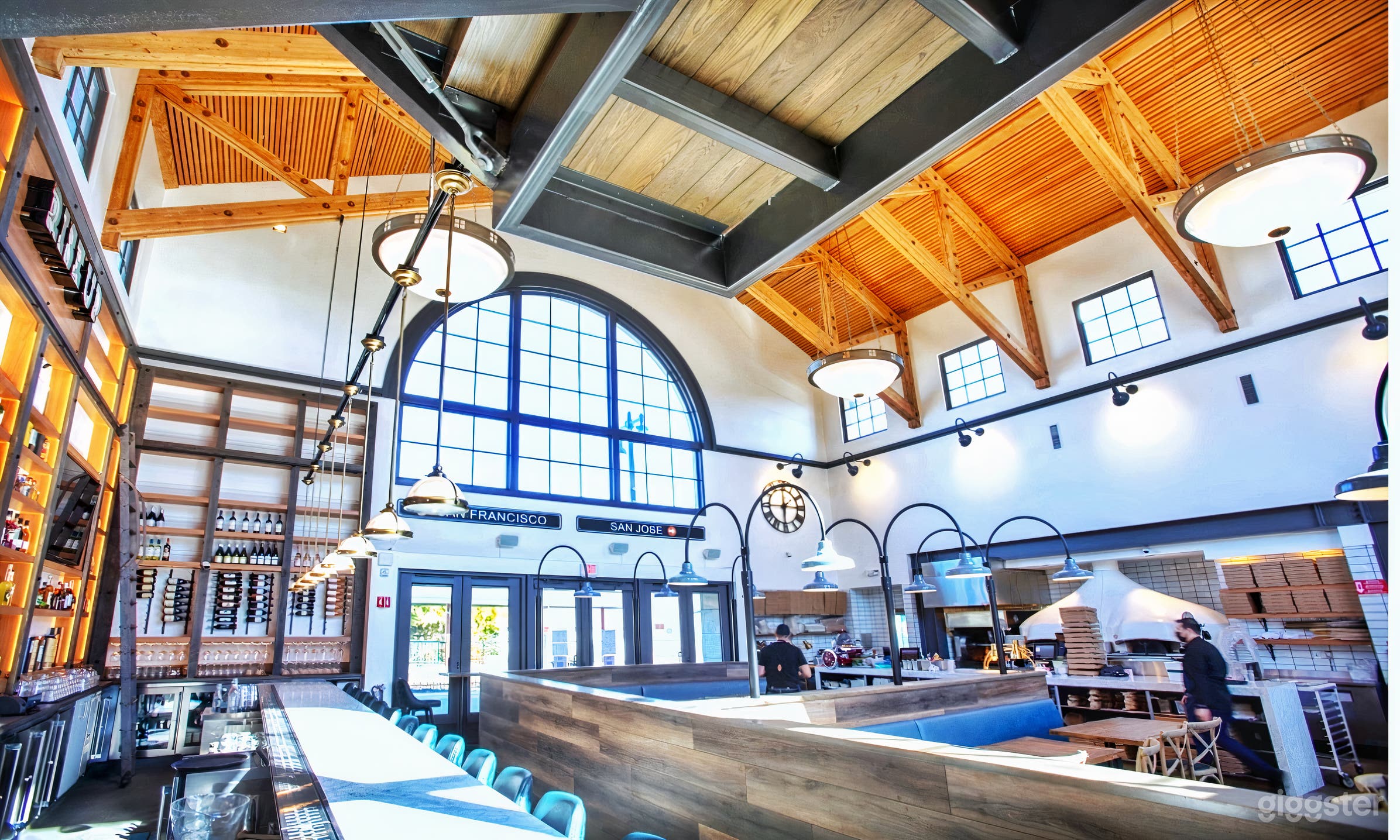 Grand main dining room located in a historic train station next to Caltrain. High ceilings, full bar with long marble top, rustic and industrial chic touches, rotisserie oven, and two imported Italian pizza ovens as the beating heart of the restaurant.