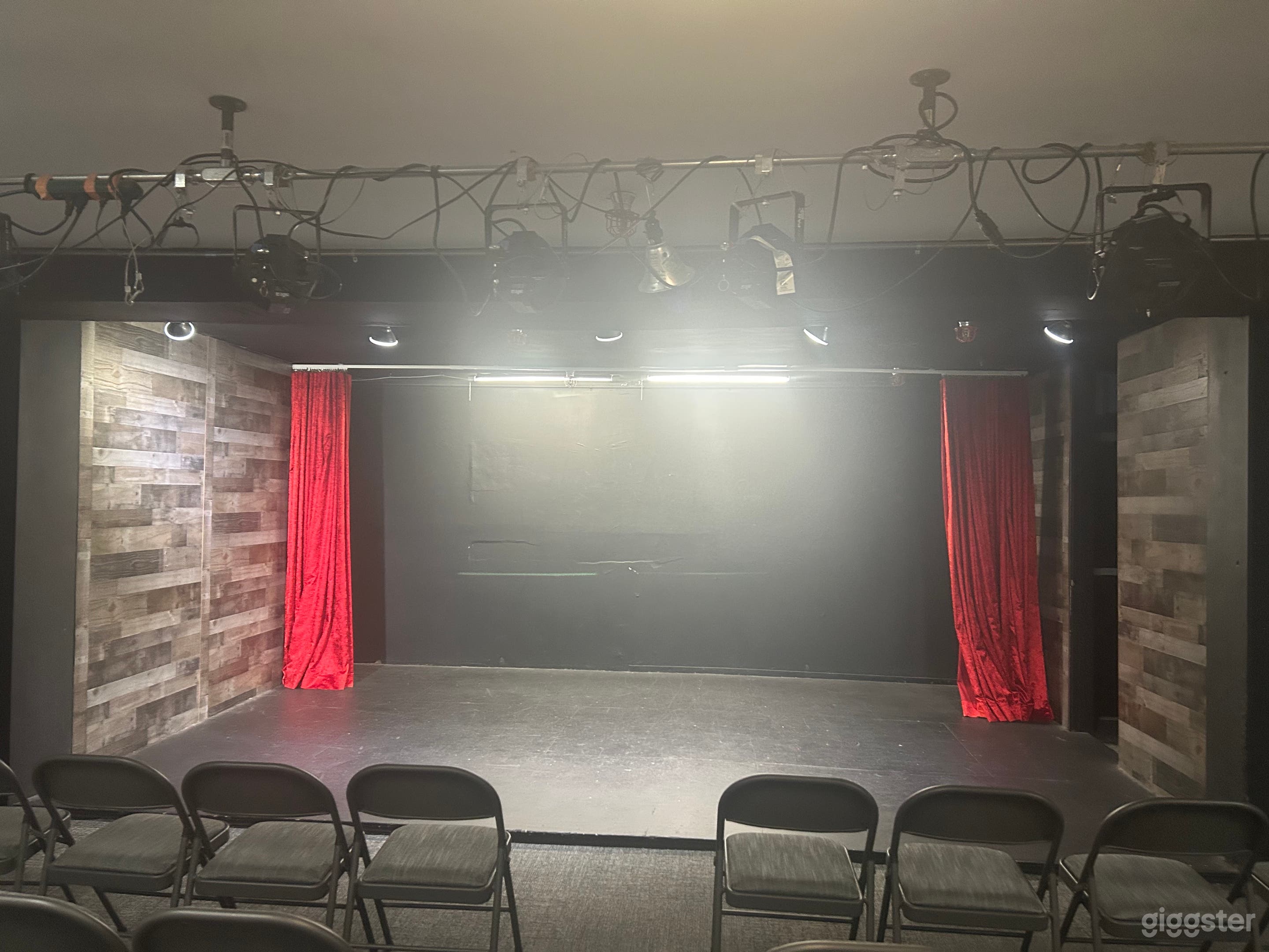 Black box stage. Optional red curtain. 50 sq. feet