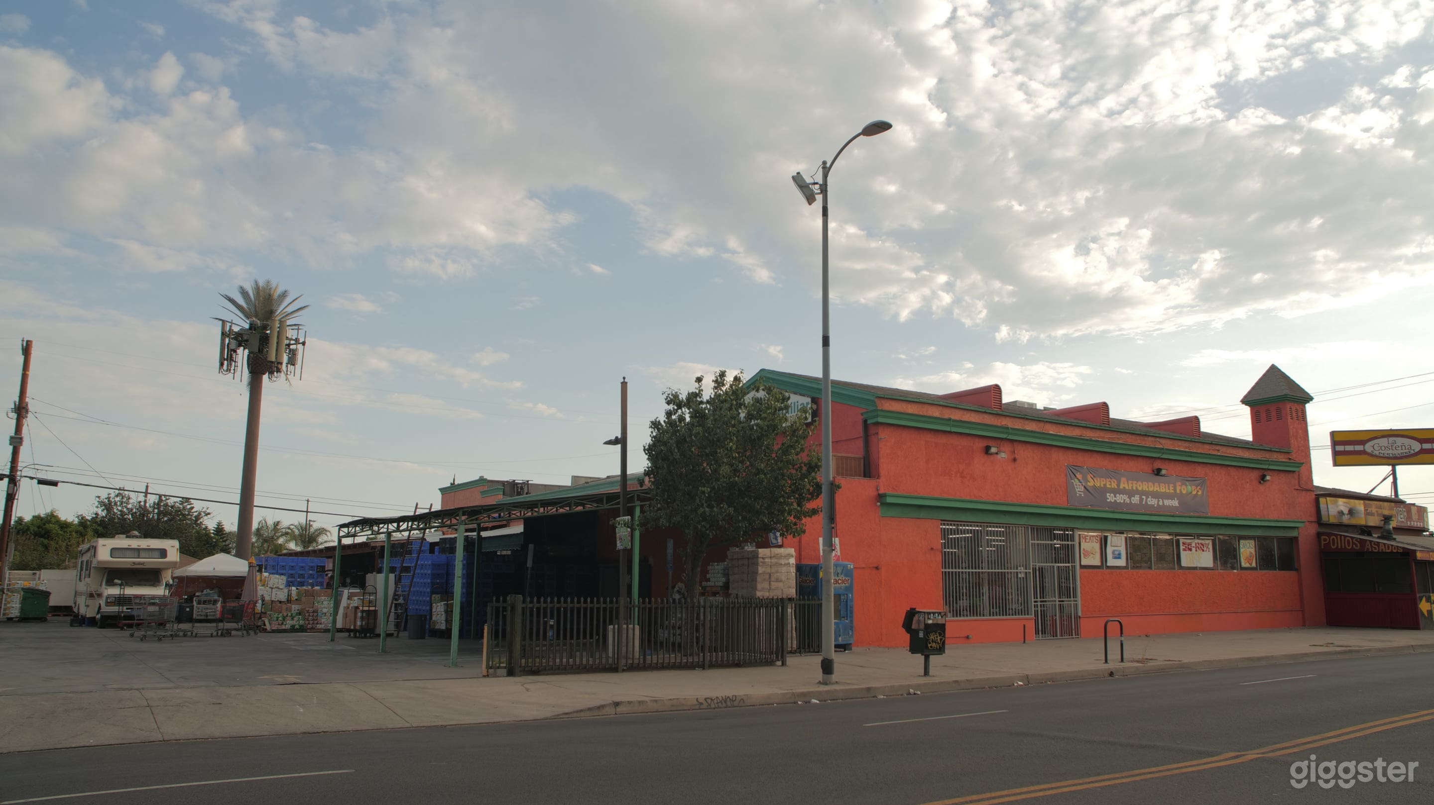 Exterior Storefront. Fenced in parking lot with 25 spaces available, trailer / truck parking, and street-level load in. 