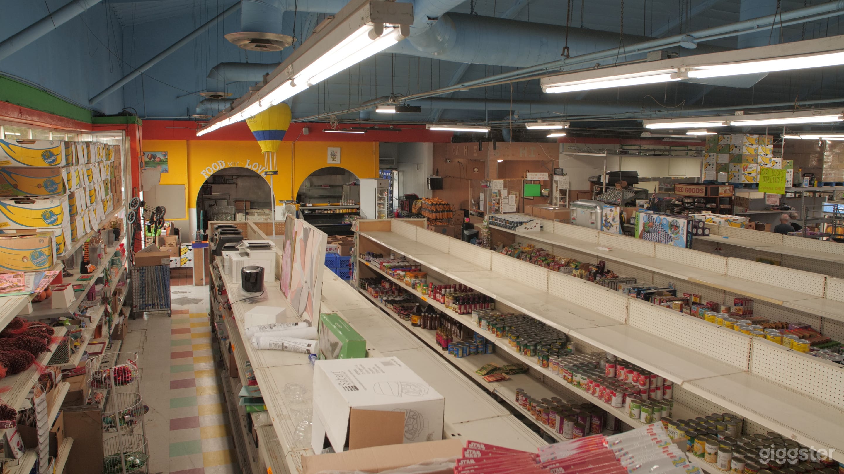 Main Interior. Mid-sized grocery store with bakery and food court type space, industrial kitchen, standing coolers, four grocery aisles and vaulted ceilings.