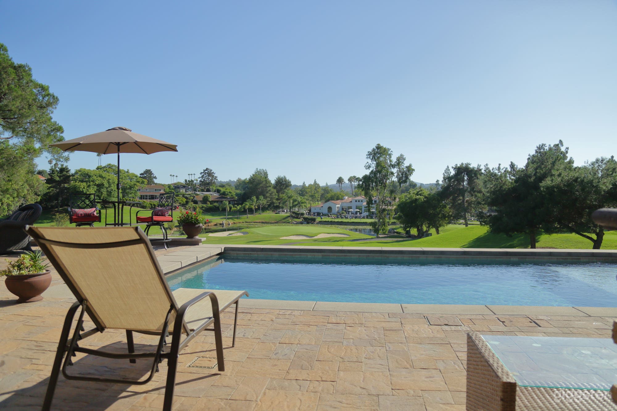 Pool side. View of beautiful Country Club, pond with two fountains, panoramic golf course view