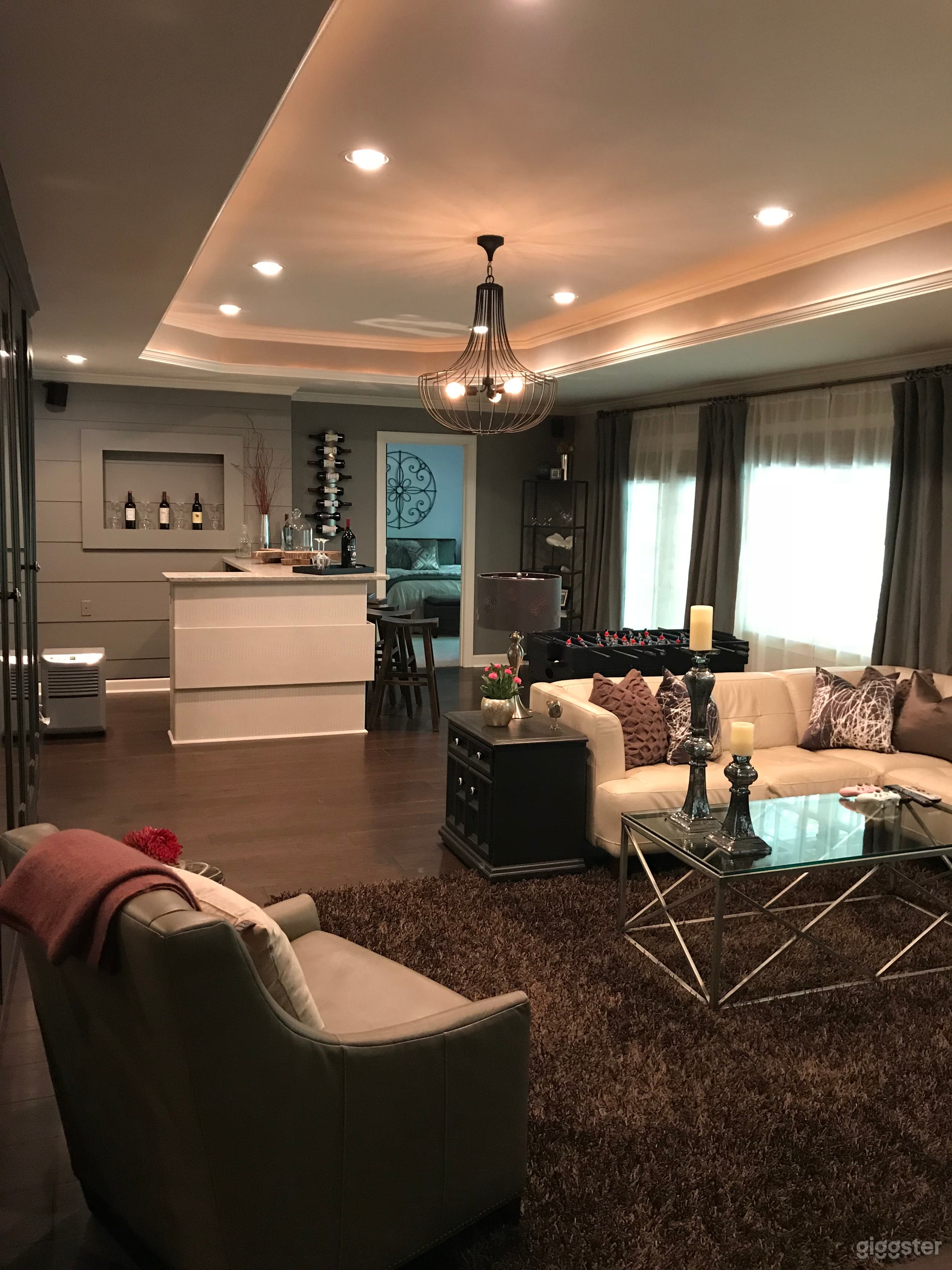 Contemporary walk-out basement with guest bedroom, bar, kitchenette for crew food, bathroom, and small gym.