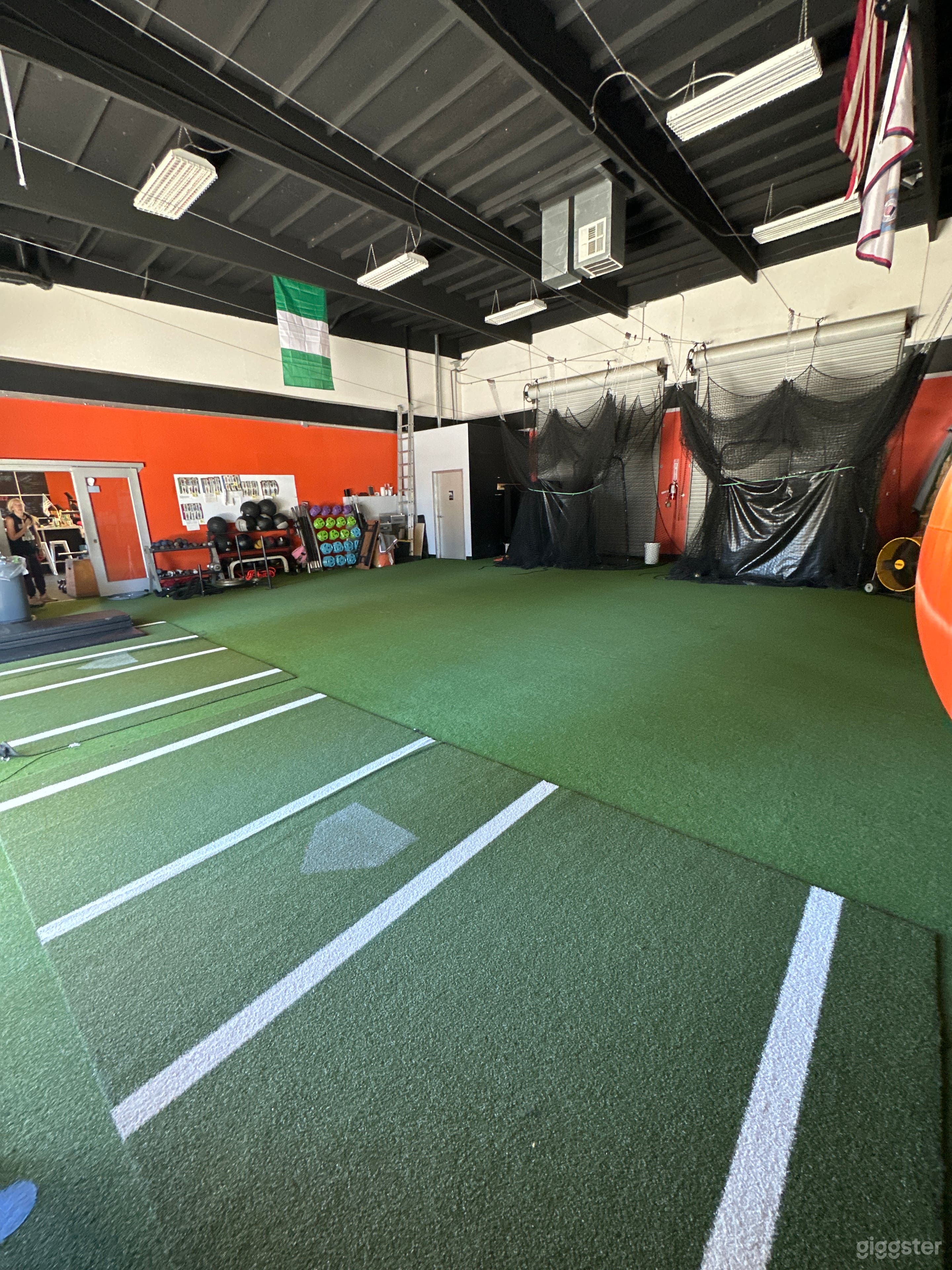 Nets in the back are batting cages that can be pulled out and used or rolled back in to open the space.