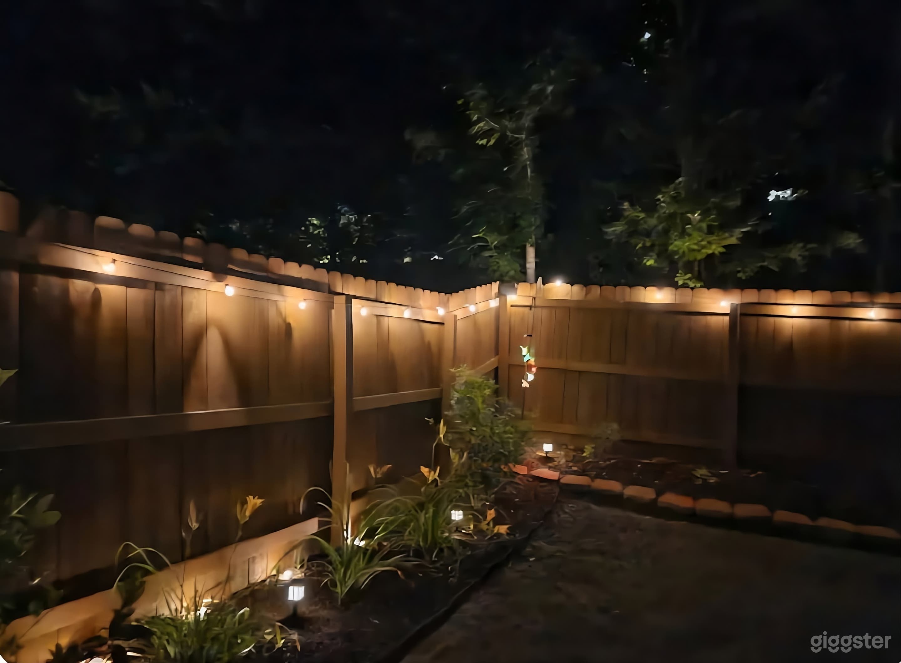 Stunning Fenced Backyard with Accent Lighting Photo 4