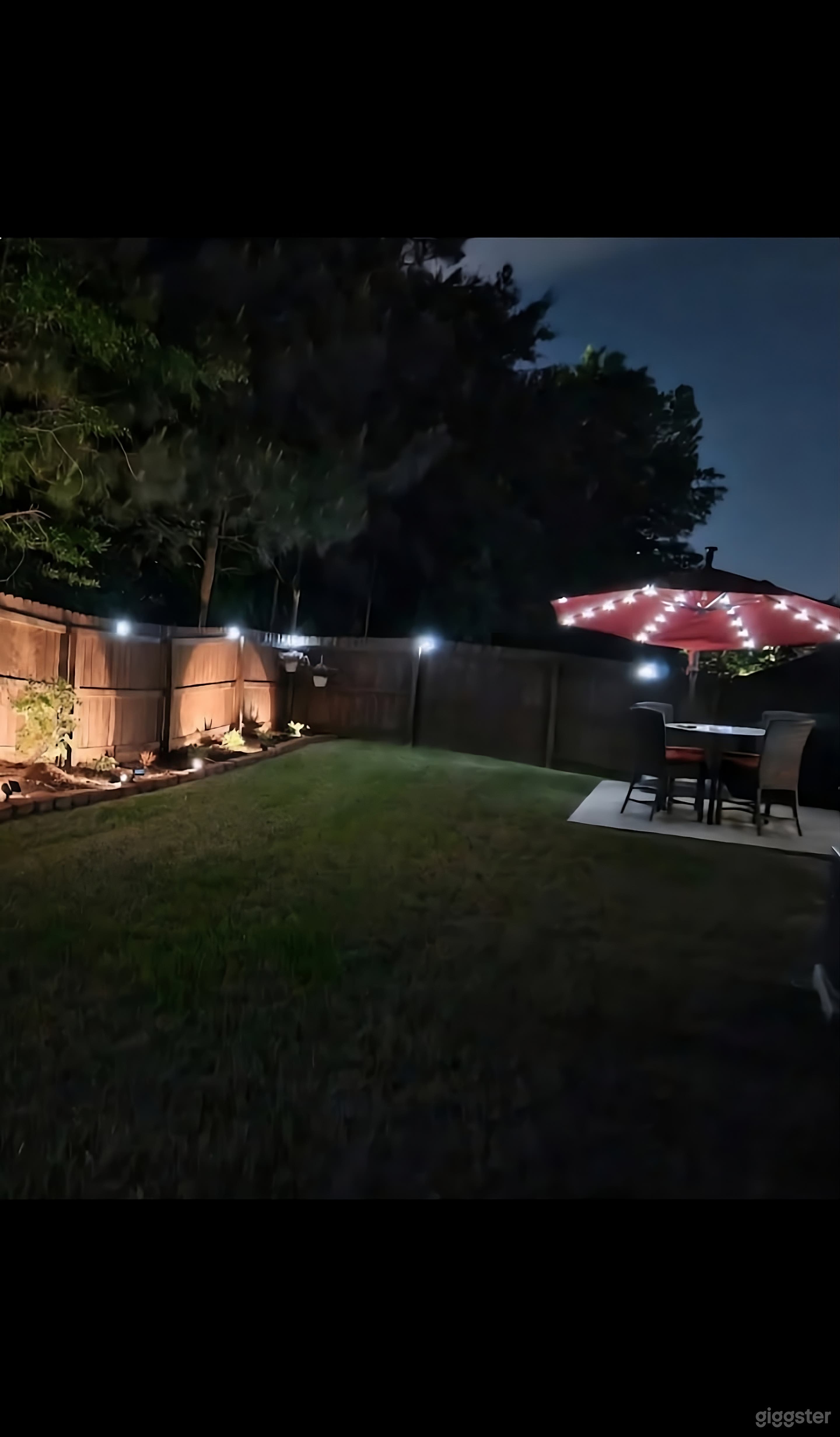 Stunning Fenced Backyard with Accent Lighting Photo 3
