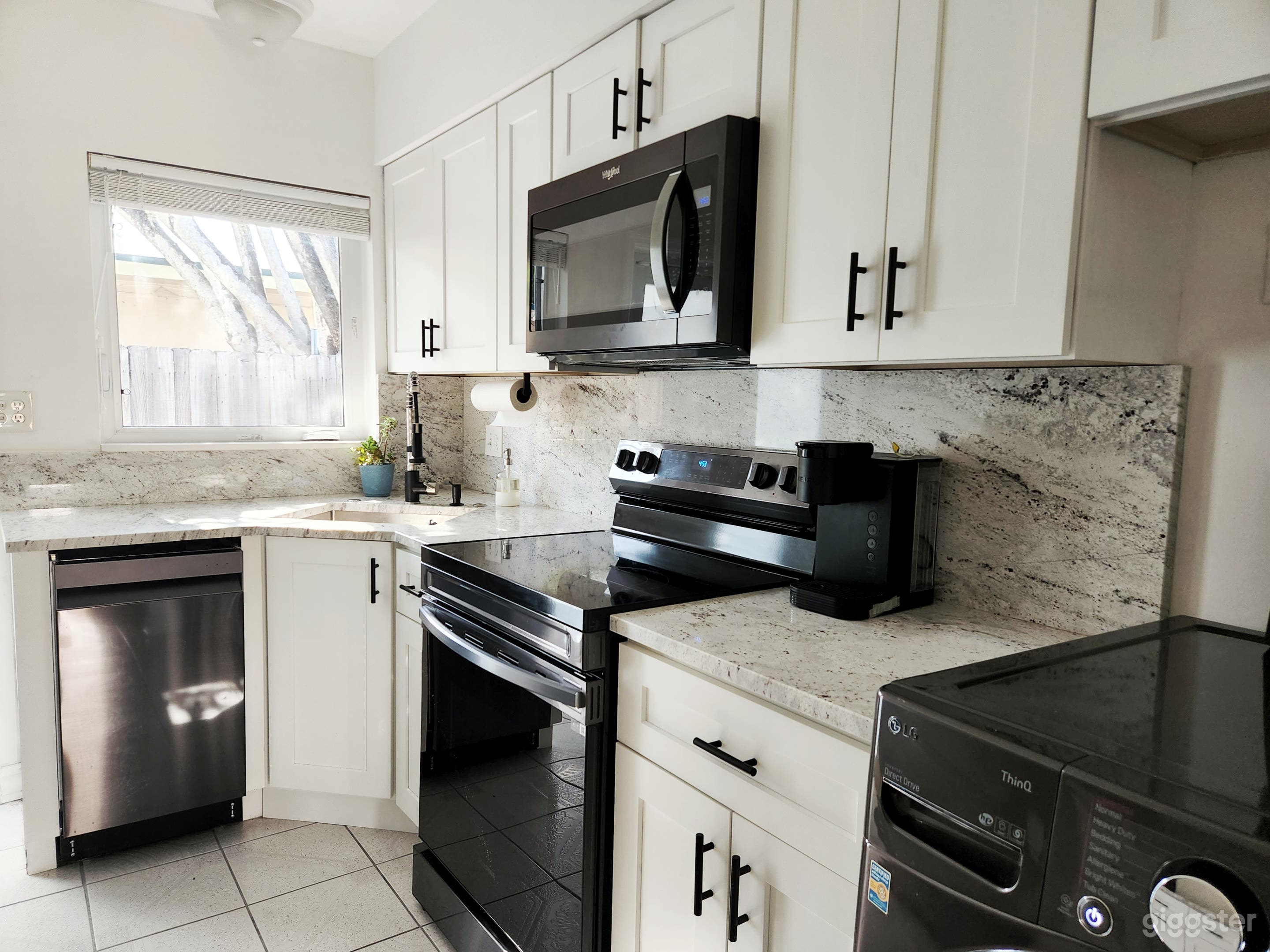 White kitchen with black stainless steel appliances