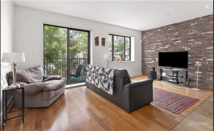 Living room area the combination of exposed brick and white walls with easy access to the outdoor balcony