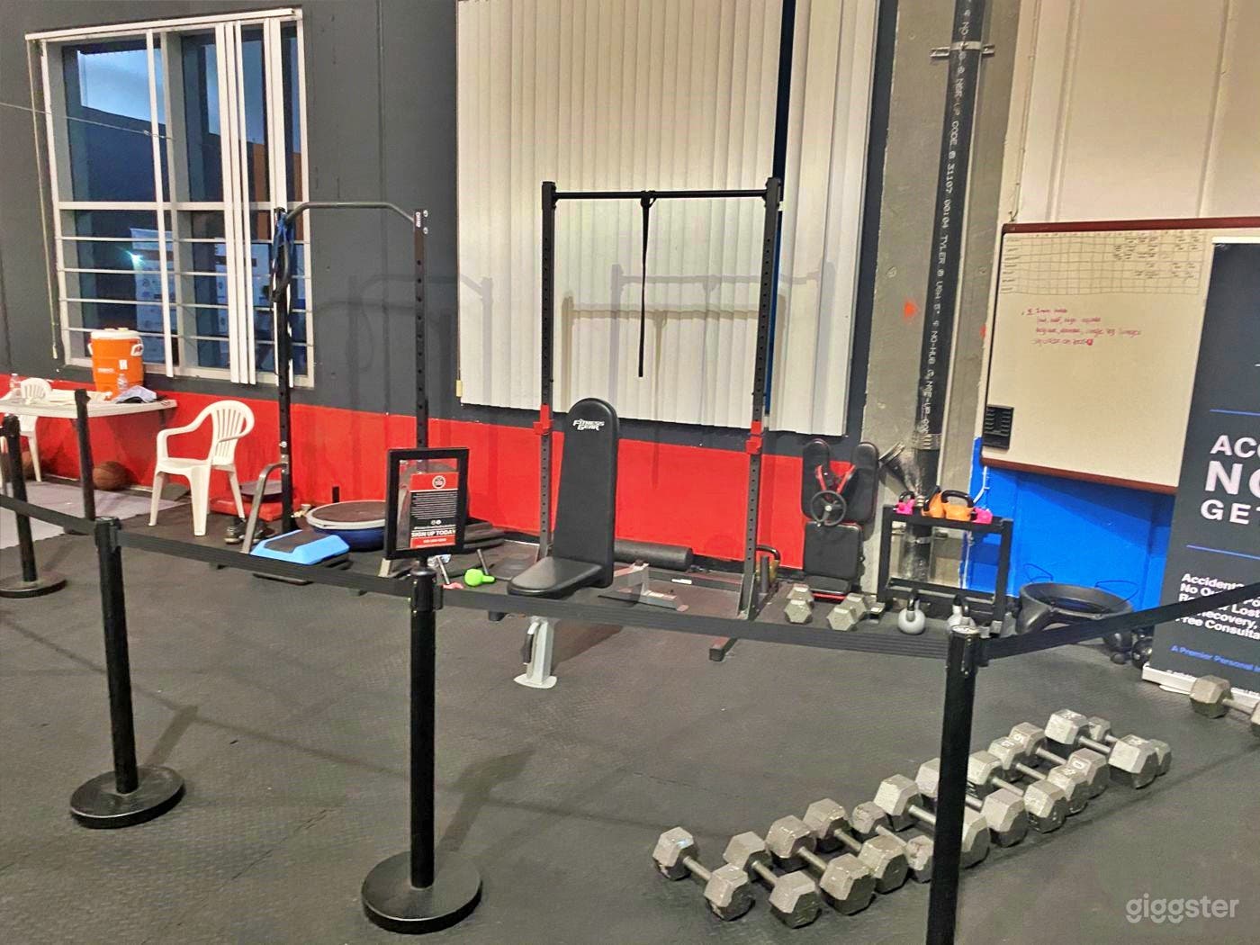 fitness area with 2 sets of weights, bench press and treadmill. 