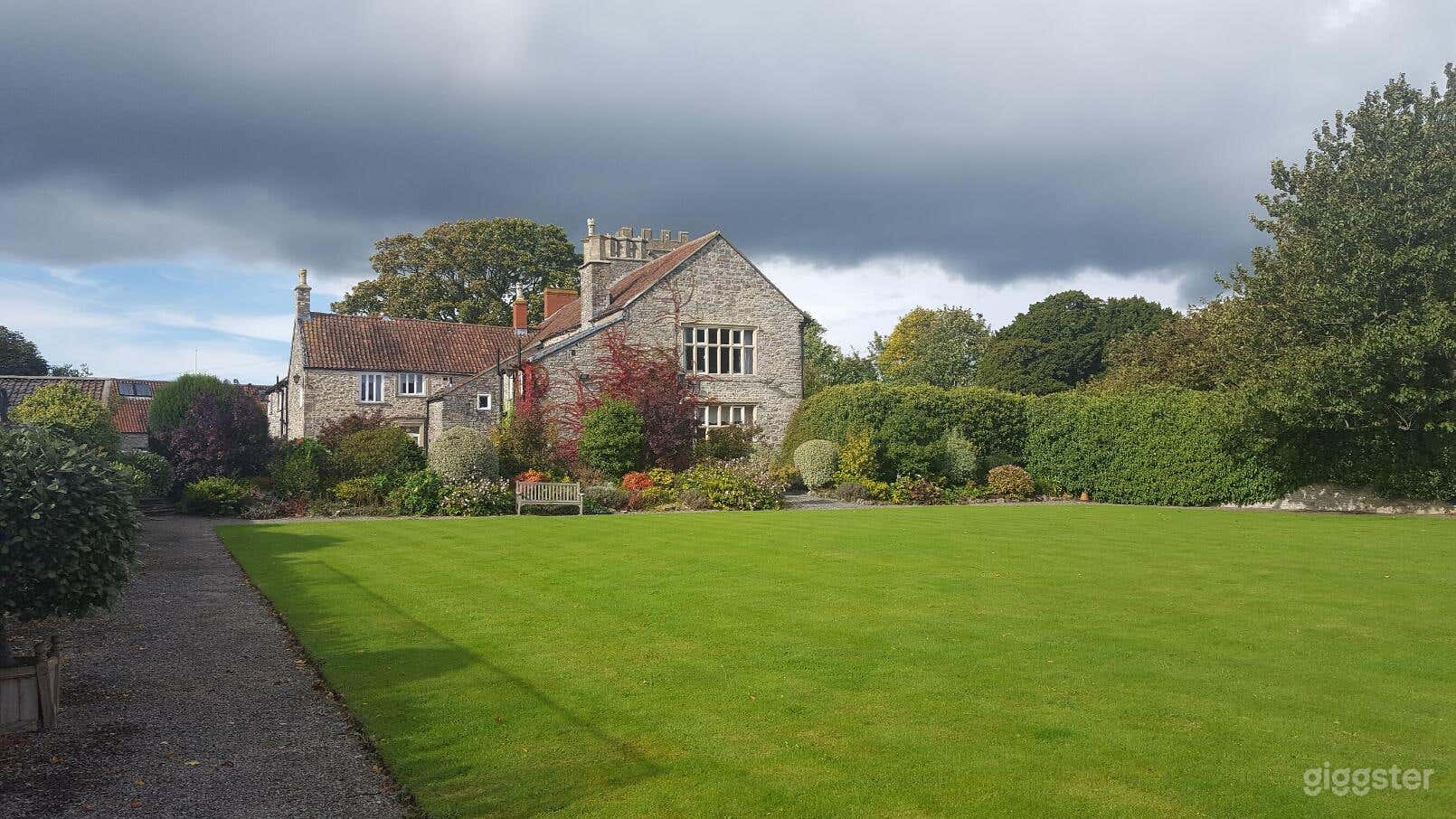 View of the South aspect of the house seen from the croquet lawn (50' x 45') with ornamental shrubs.