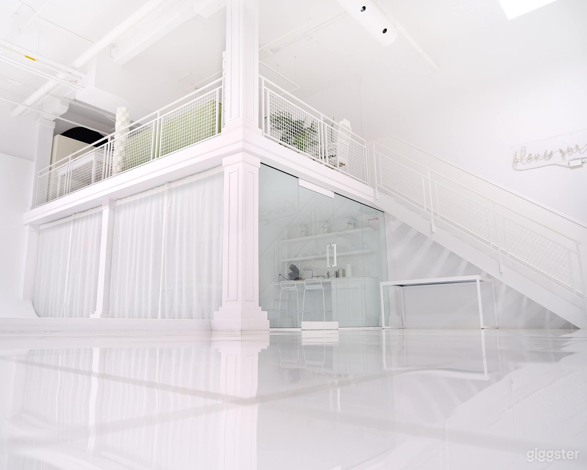 Escalier menant à la mezzanine qui abrite un coin salon et un espace bureau.

Staircase leading to the mezzanine, which houses a seating area and an office space.