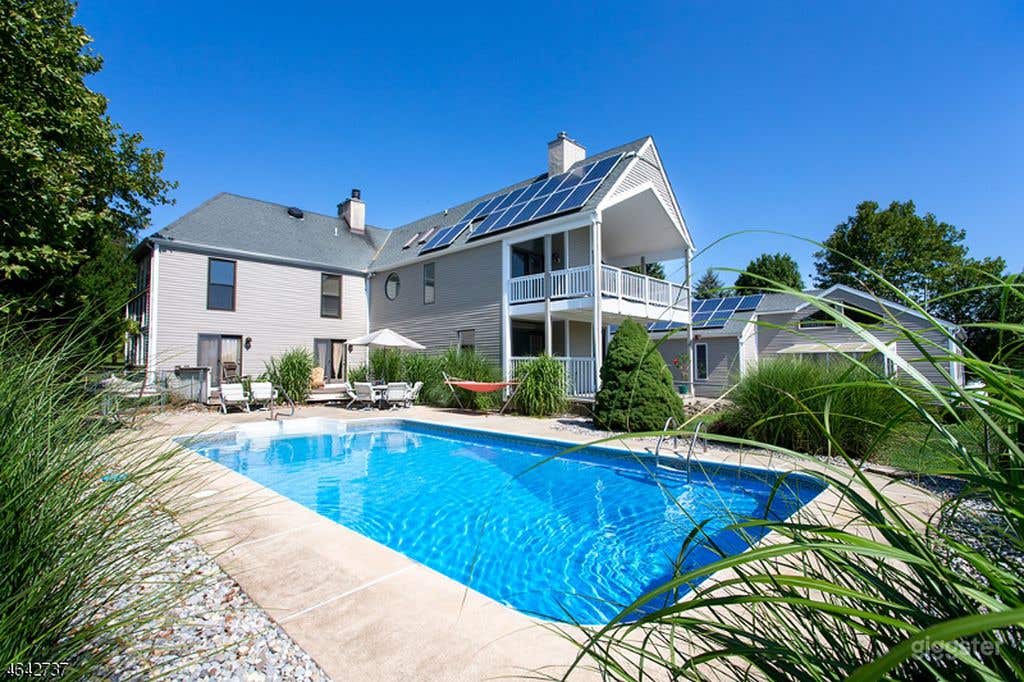 Rear in-ground pool with covered porches and exterior lounge areas.