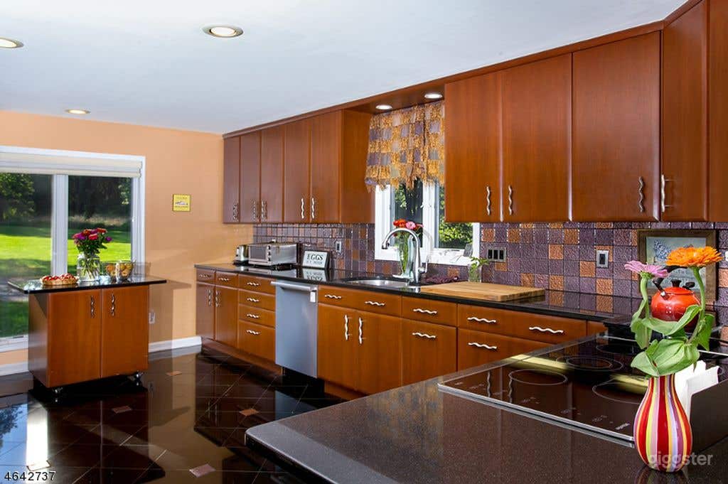 Open floor plate kitchen with stone countertops and granite and glass flooring.