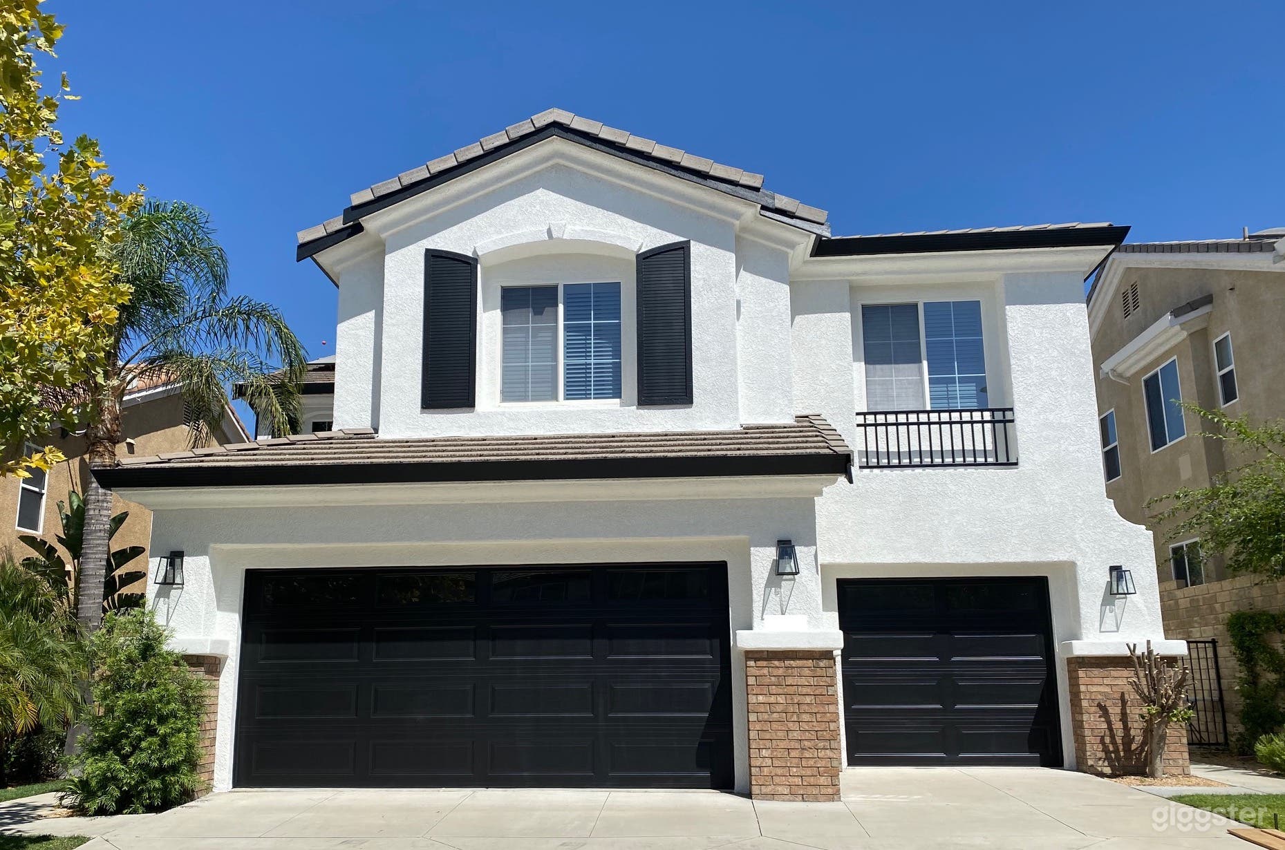 Modern black and white house exterior on quiet street.