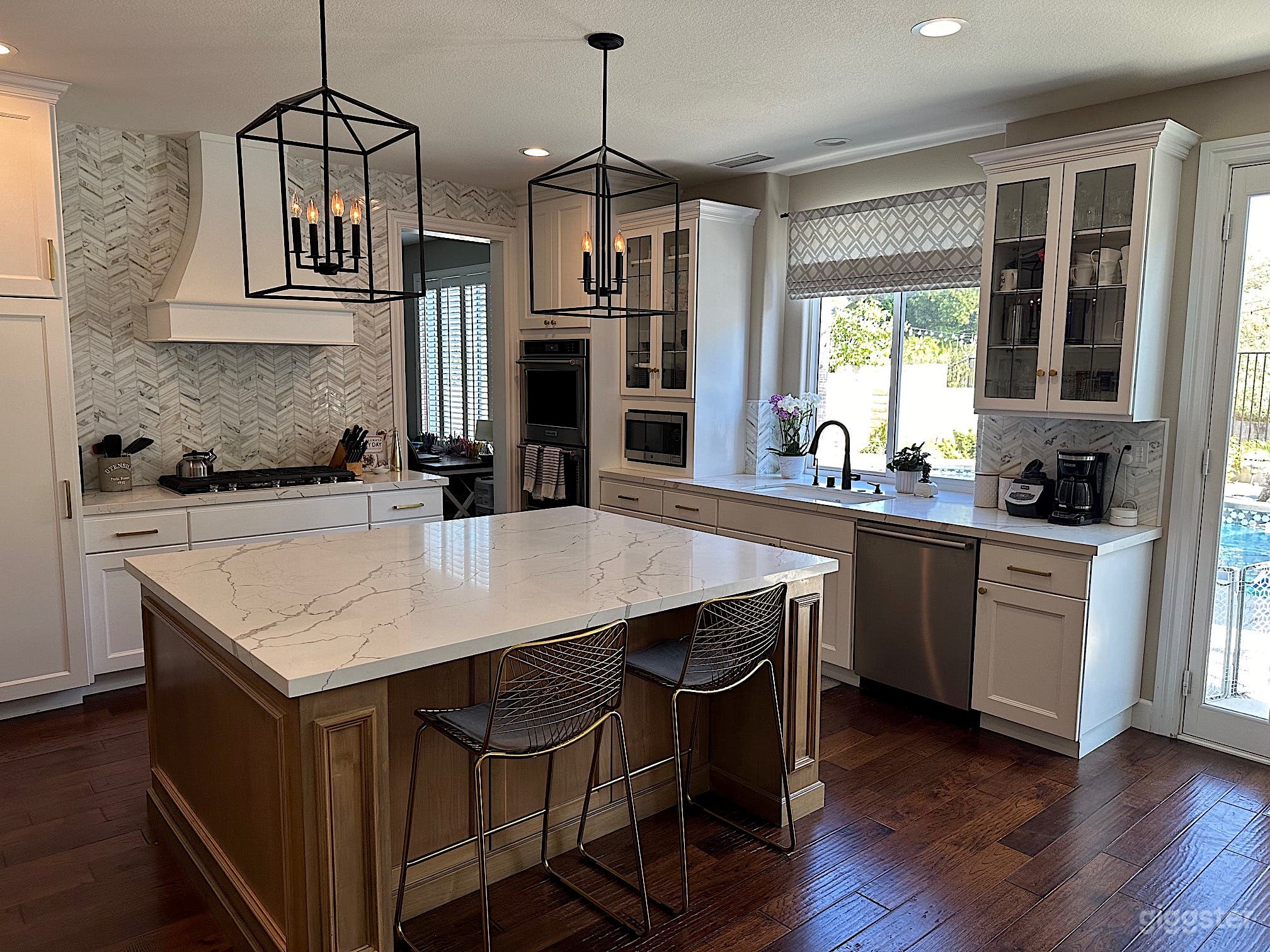 Open concept white chef's kitchen with light wood island.  Great natural light.