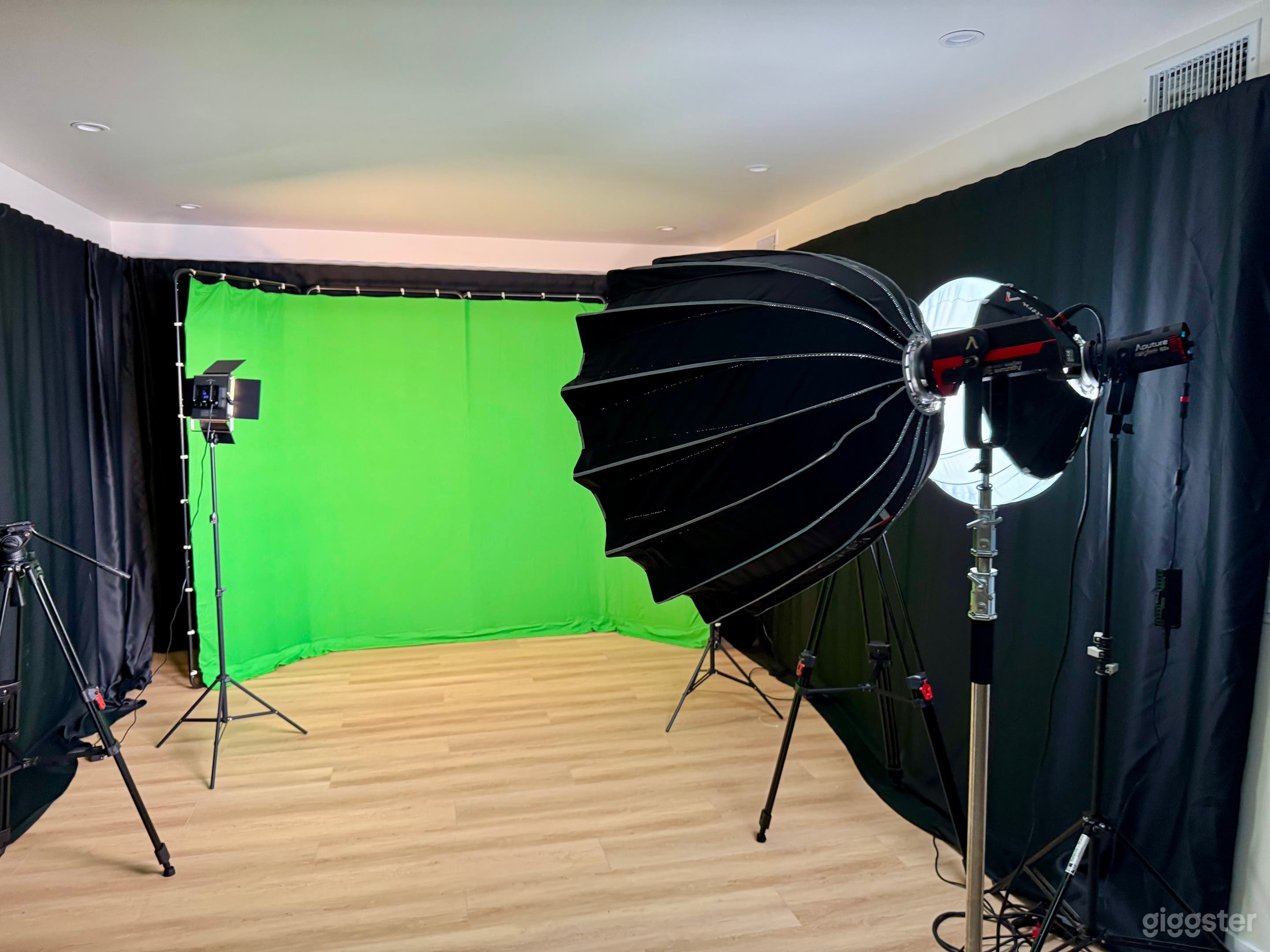 Side view of the green screen with softbox lights and tripods arranged for filming