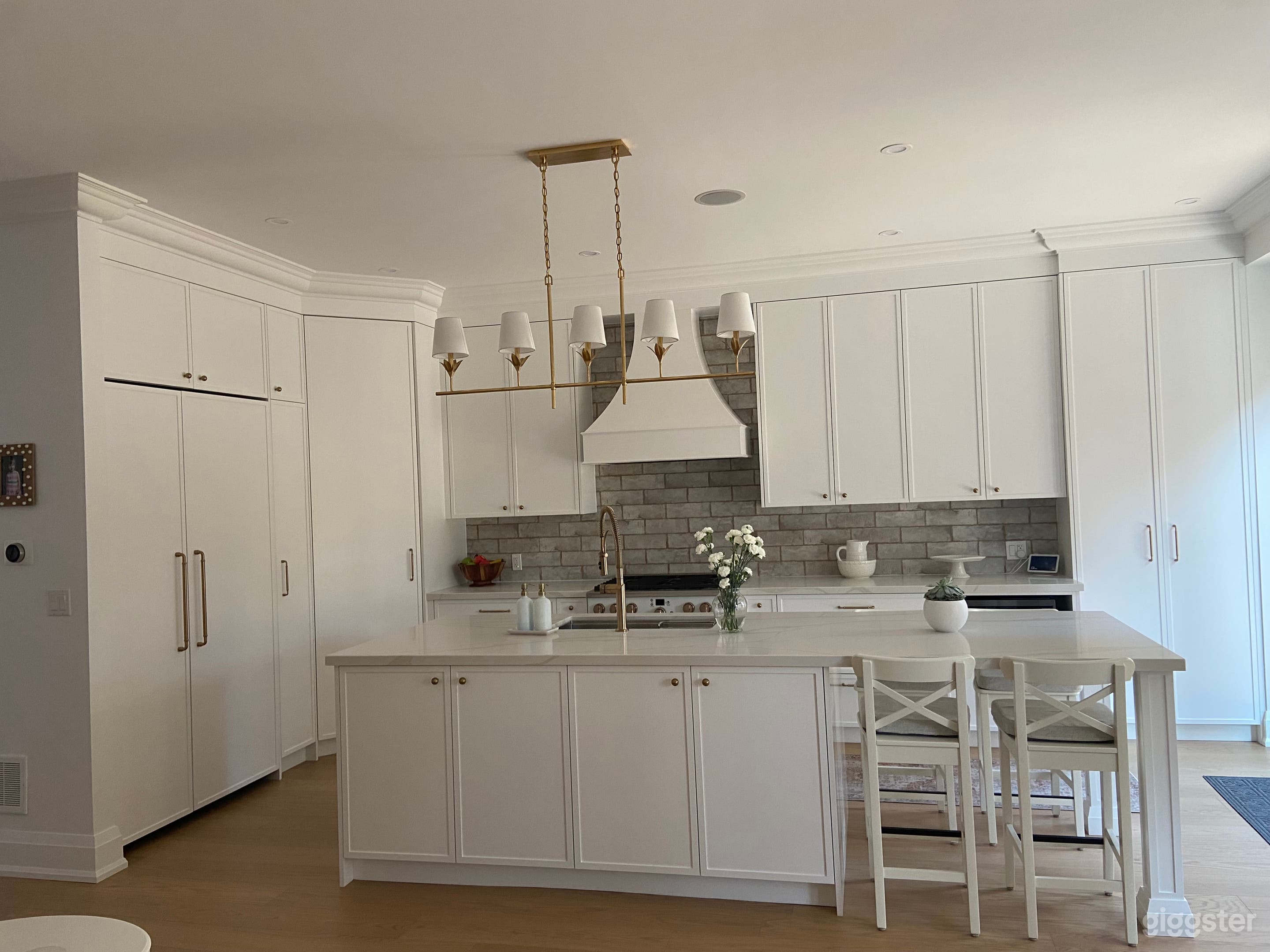 Newly renovated modern traditional kitchen with loads of room for cameras in the adjoining area.White with brass fixtures. 