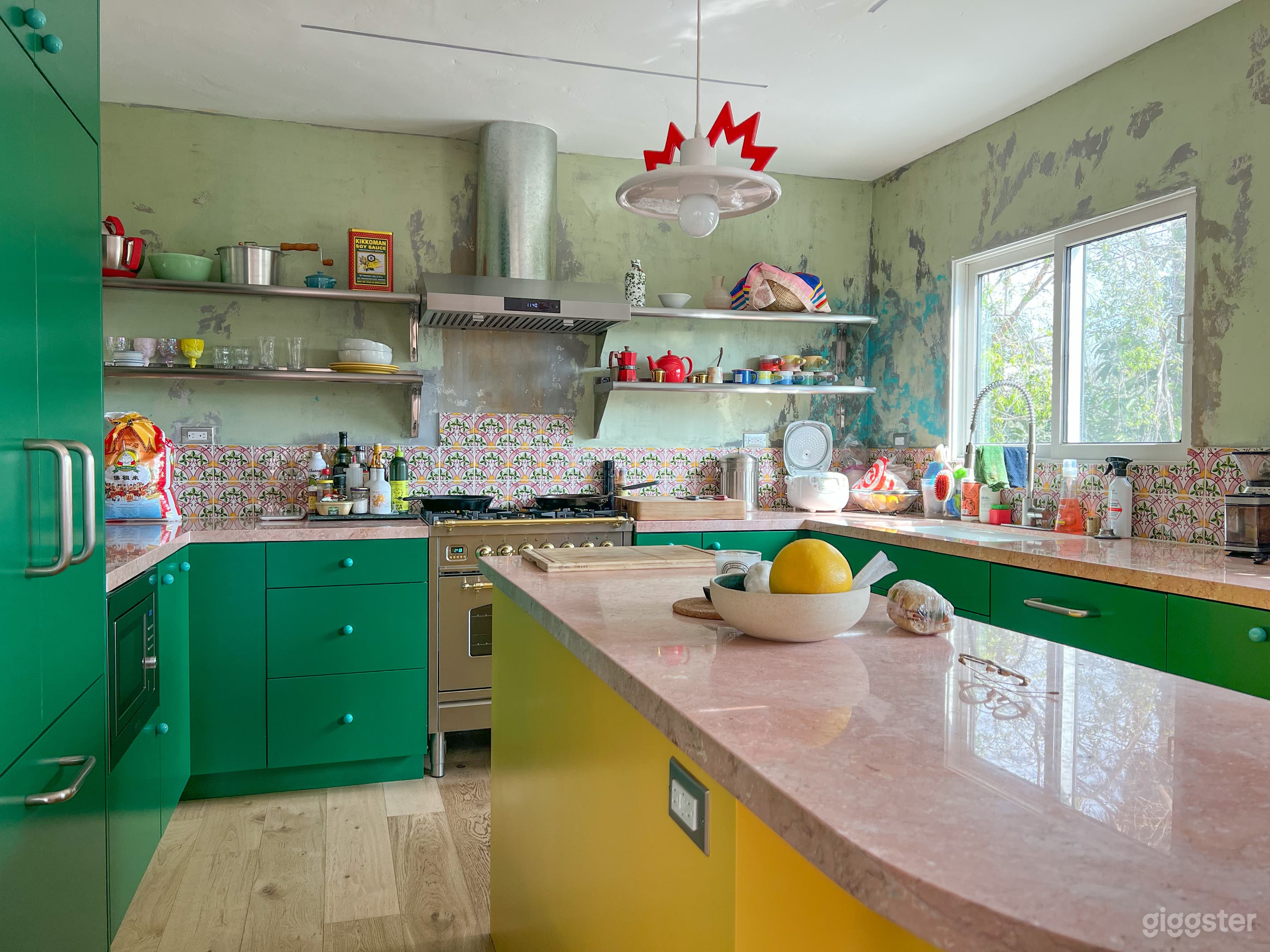 Gourmet kitchen with pink Italian marble countertops, industrial shelving, Portuguese tile backsplash 