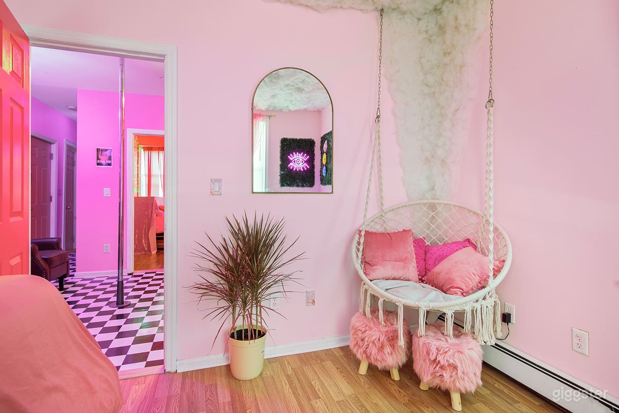 Pink Boho Zen room. Features led cloud ceiling, neon lights, swing chair and boho decor.