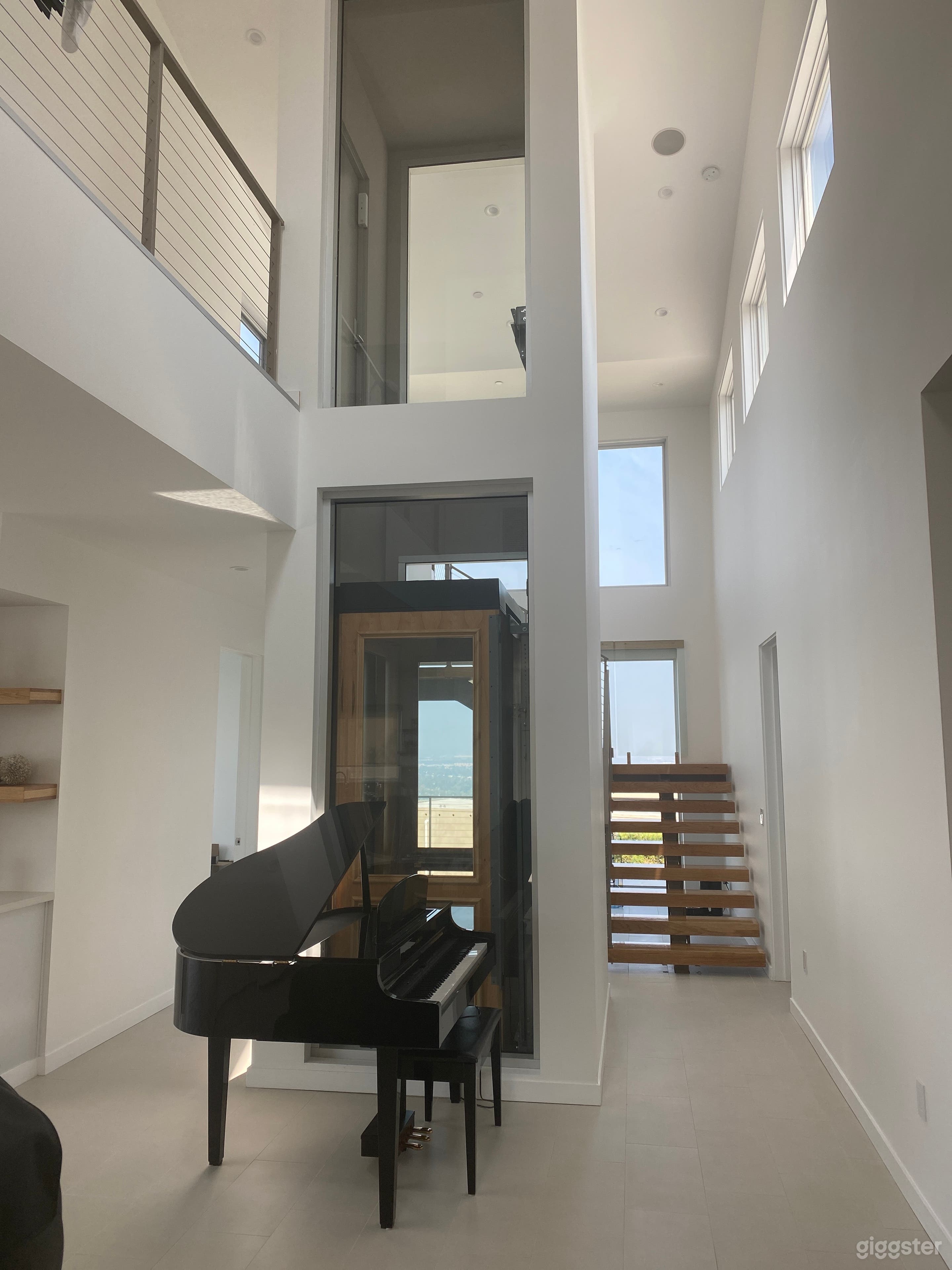 Glass elevator, floating stairs, baby grand