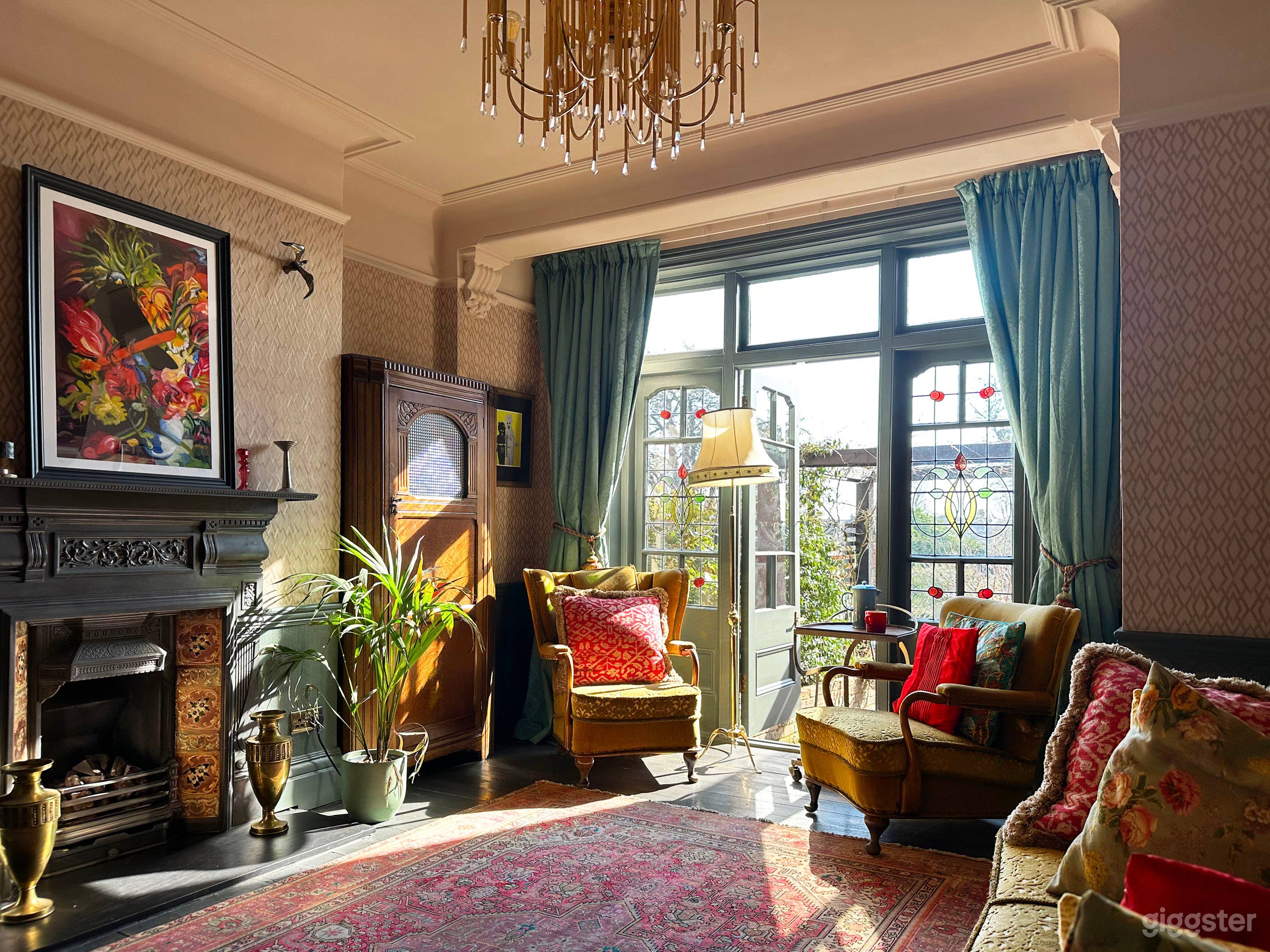 The second reception room has original stained glass French doors, cast iron tiled fireplace, Persian rug, built in cabinetry, decorated in a vintage style.