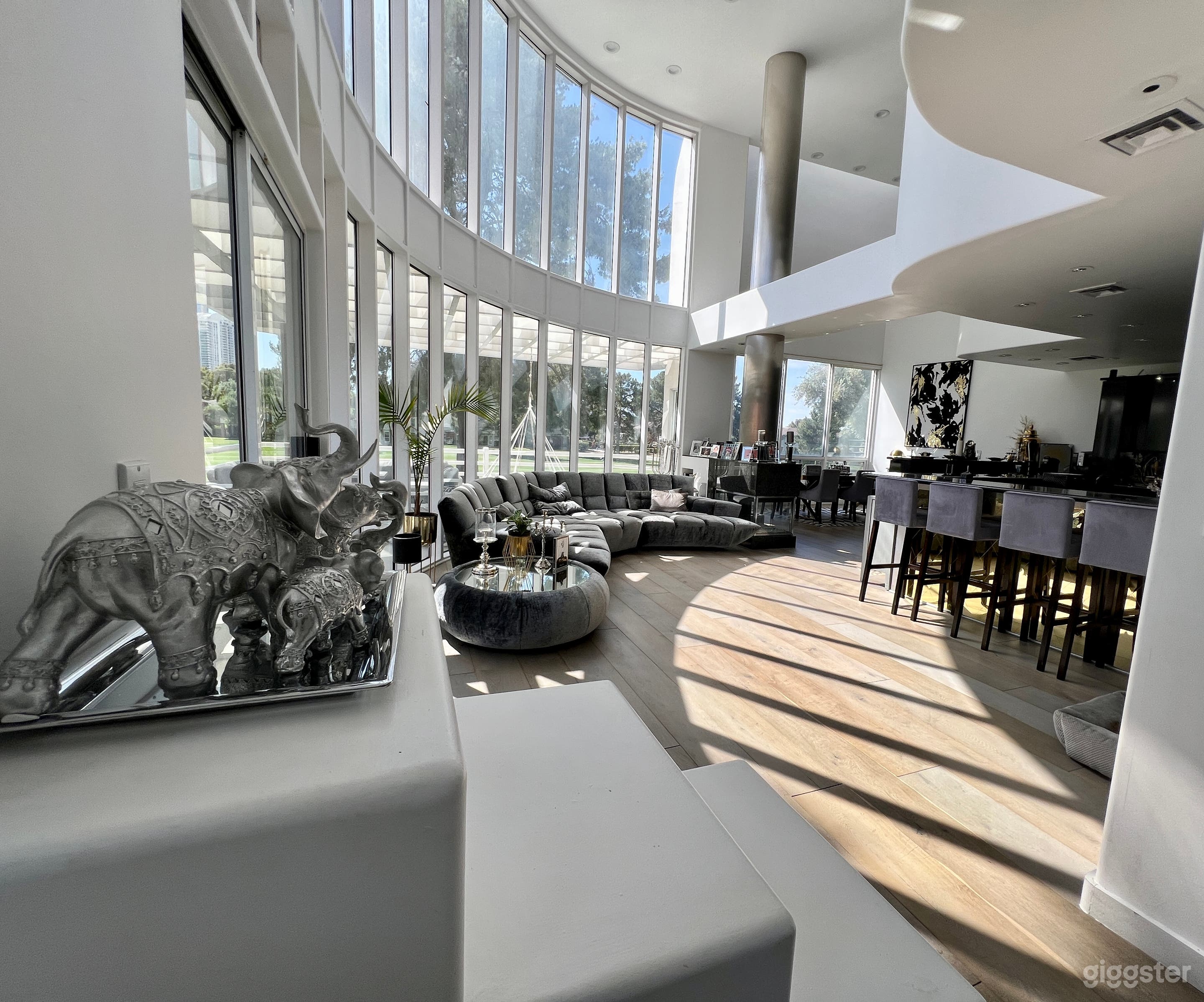 Livingroom with 18 feet high ceilings, show kitchen, fireplace and dining area. 