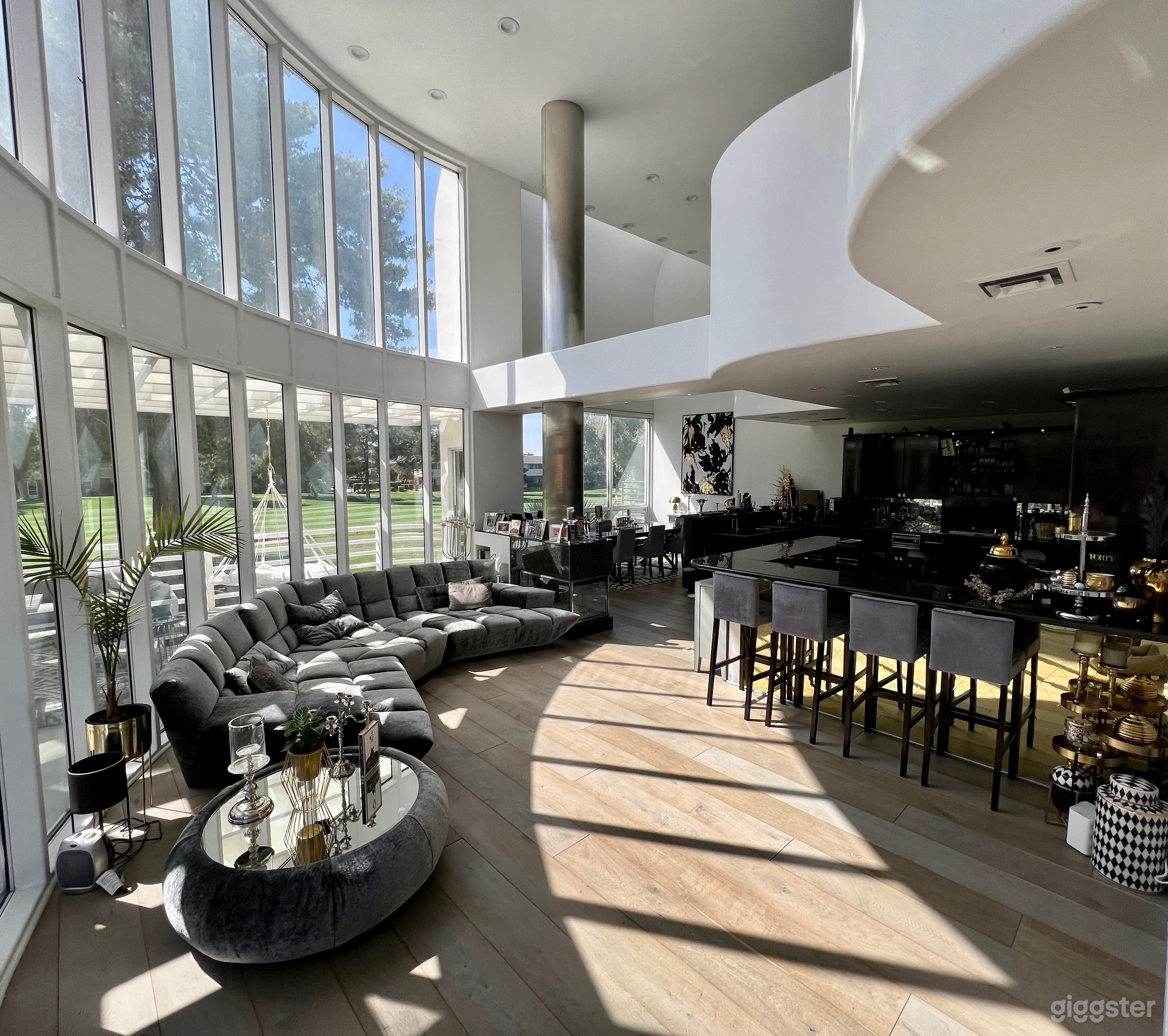 Livingroom with 18 feet high ceilings, show kitchen, fireplace and dining area. 