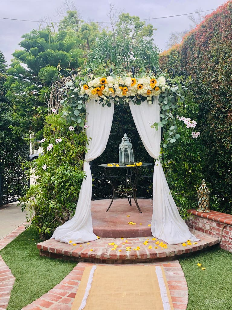  The garden is set up with an English garden style theme including a beautiful gazebo with crystal chandelier, fountain, climbing roses and brick style flower planter. 