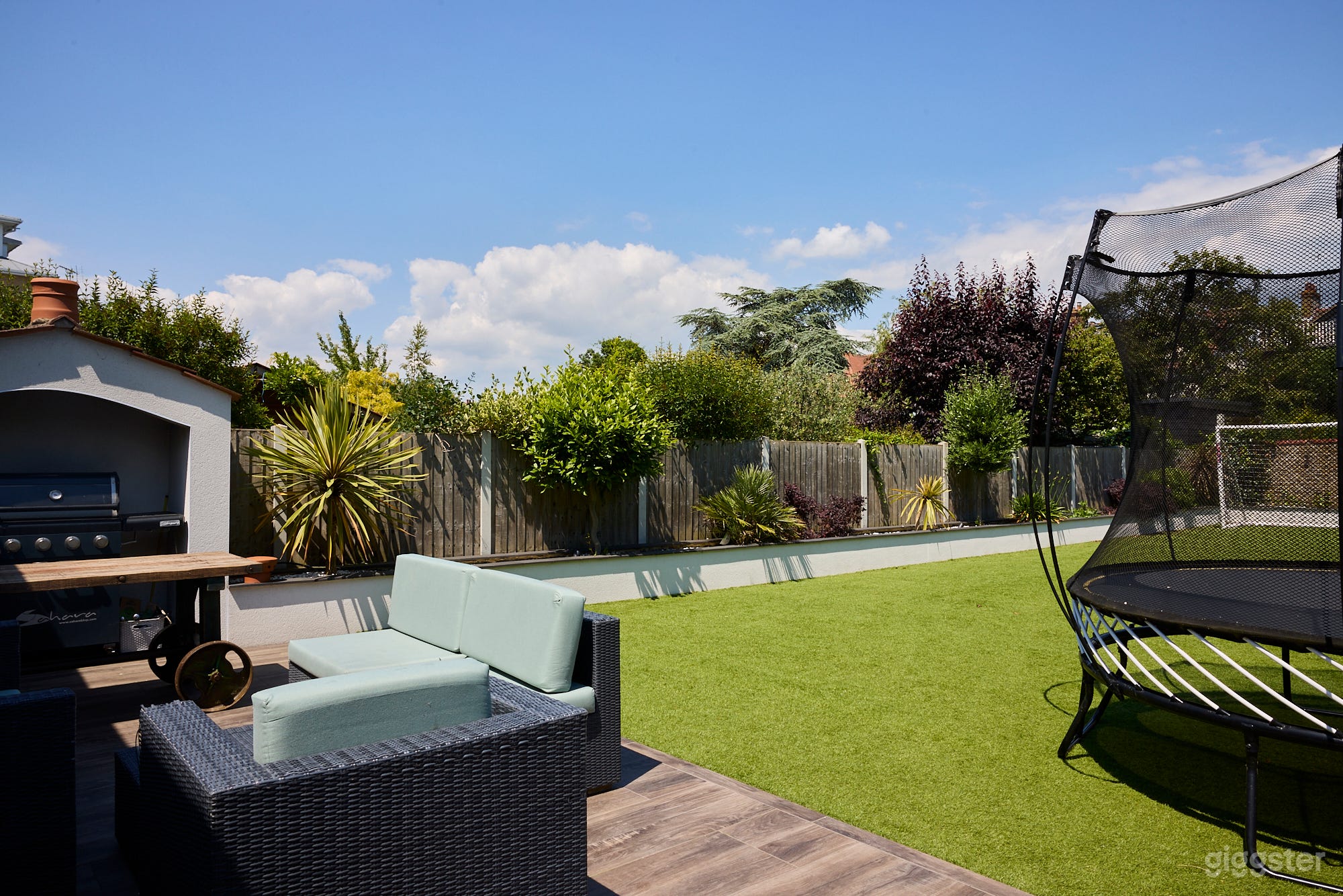 back garden, porcelain patio, artificial lawn, plant beds, BBQ.
