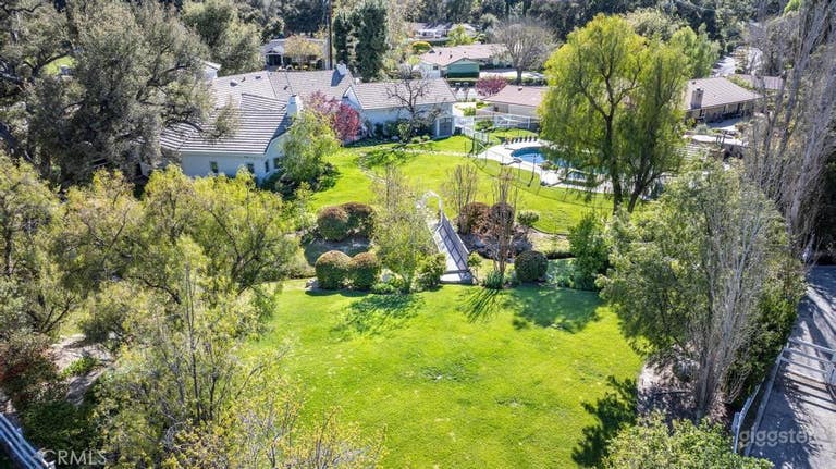  Expansive Outdoor Space with Pool, Lawn, & Bridge 