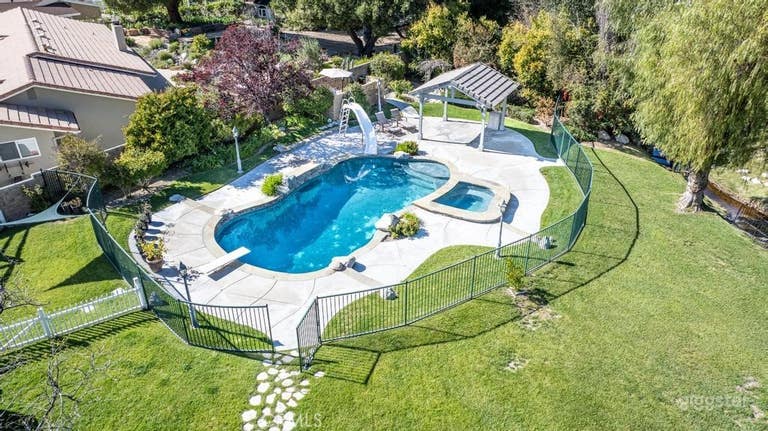  Expansive Outdoor Space with Pool, Lawn, & Bridge 