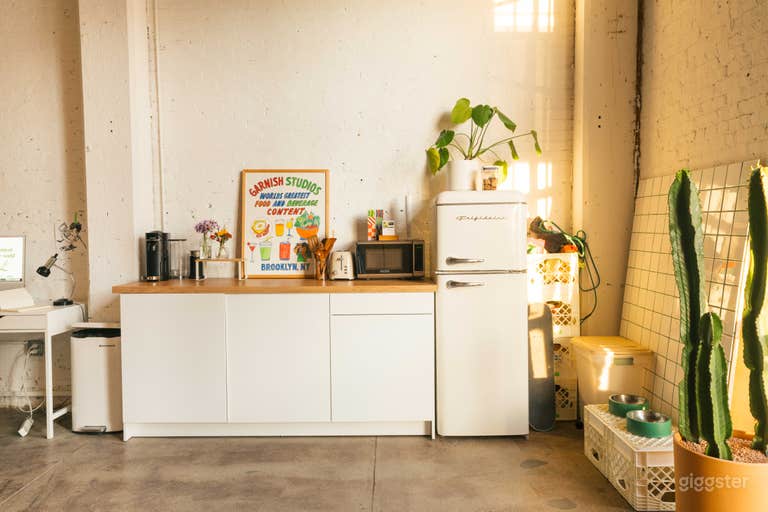  A small kitchenette that includes a fridge, microwave, and countertop space for any catering and beverage crafting.  