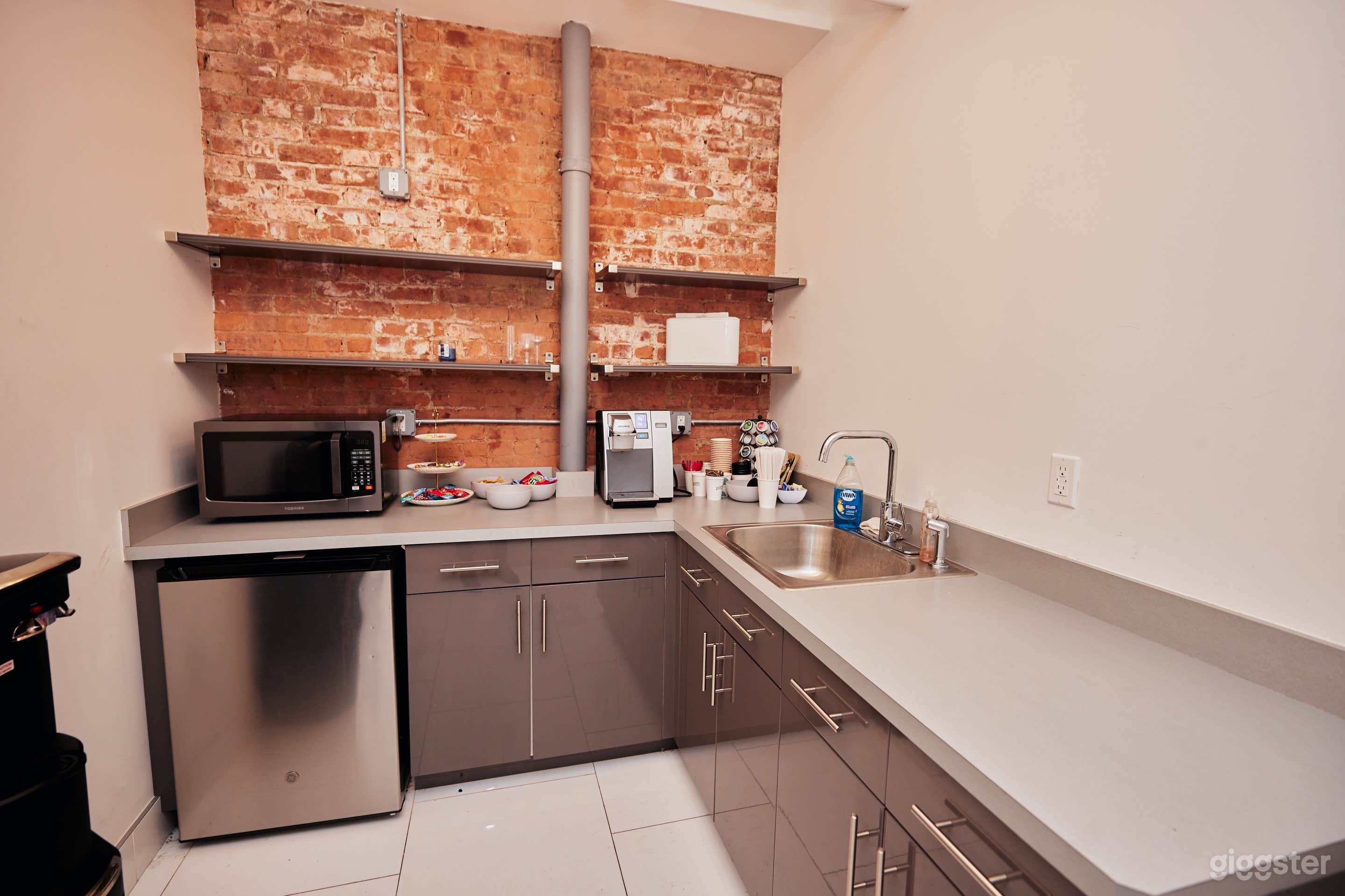 Kitchen area with storage, fridge, microwave, filtered water, snacks, coffee/tea, cooler 