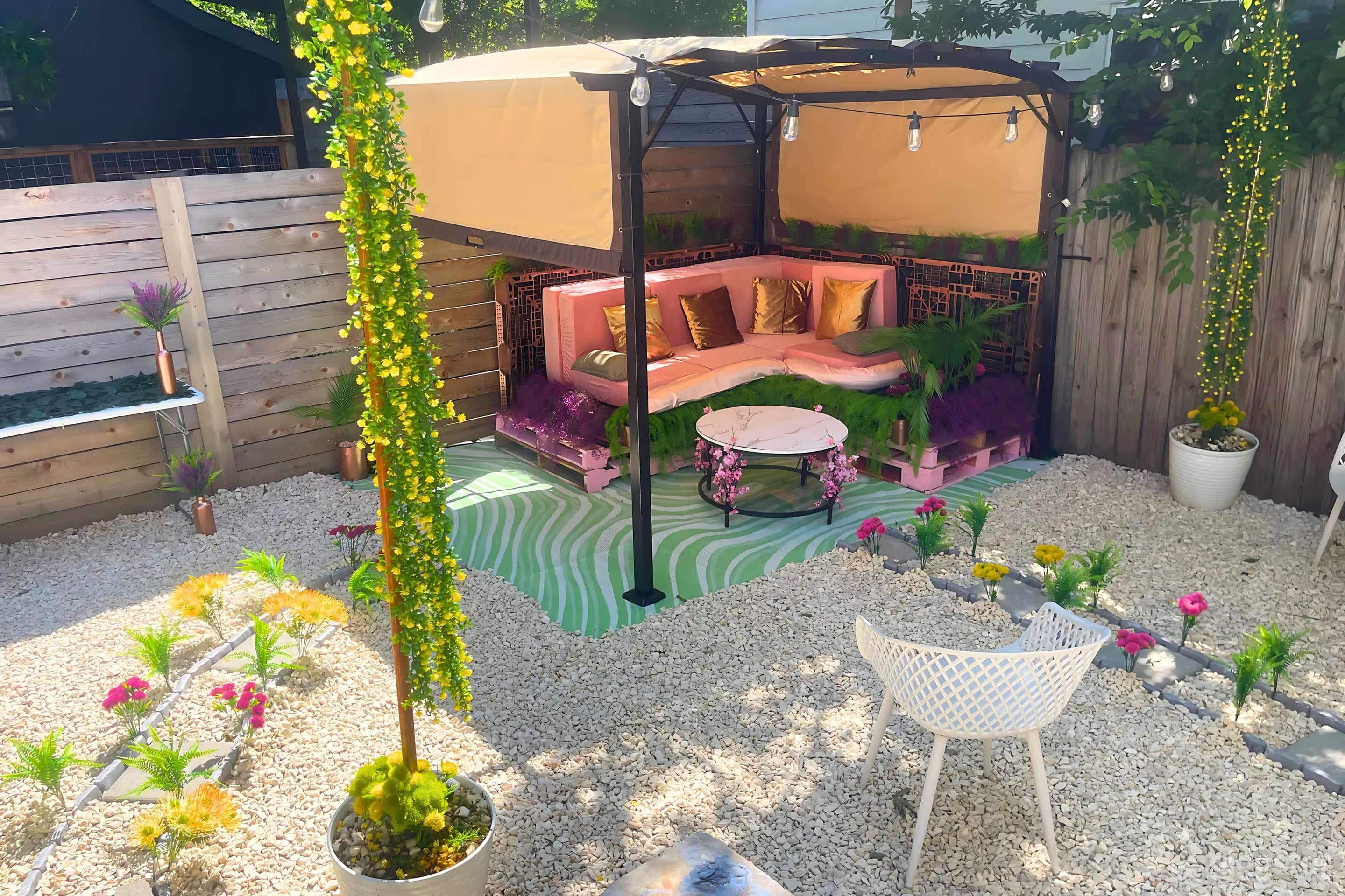 Serene outdoor space with a cozy pink and green lounge under a canopy, lush greenery, and vibrant garden accents.