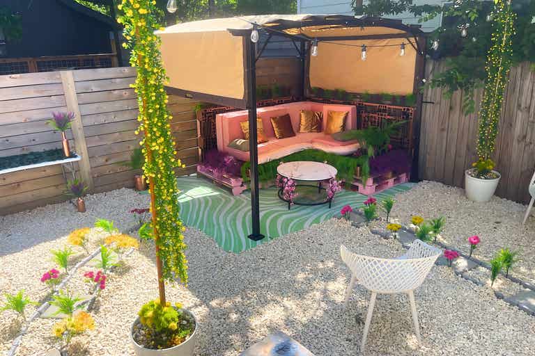  Serene outdoor space with a cozy pink and green lounge under a canopy, lush greenery, and vibrant garden accents. 