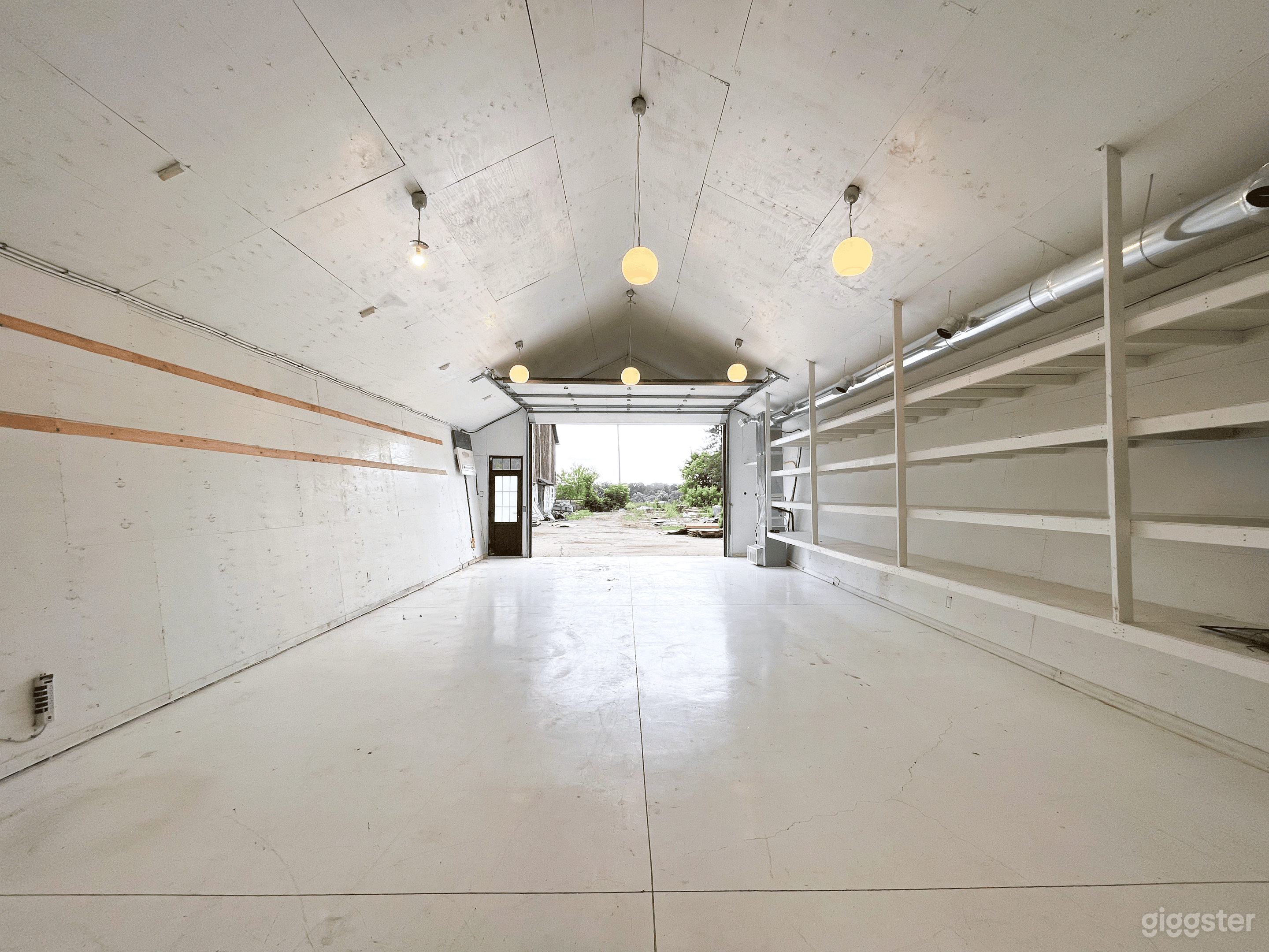 View from Cetner of the loft toward the entrance. Large Loft with Loads of shelving, Large bay door.