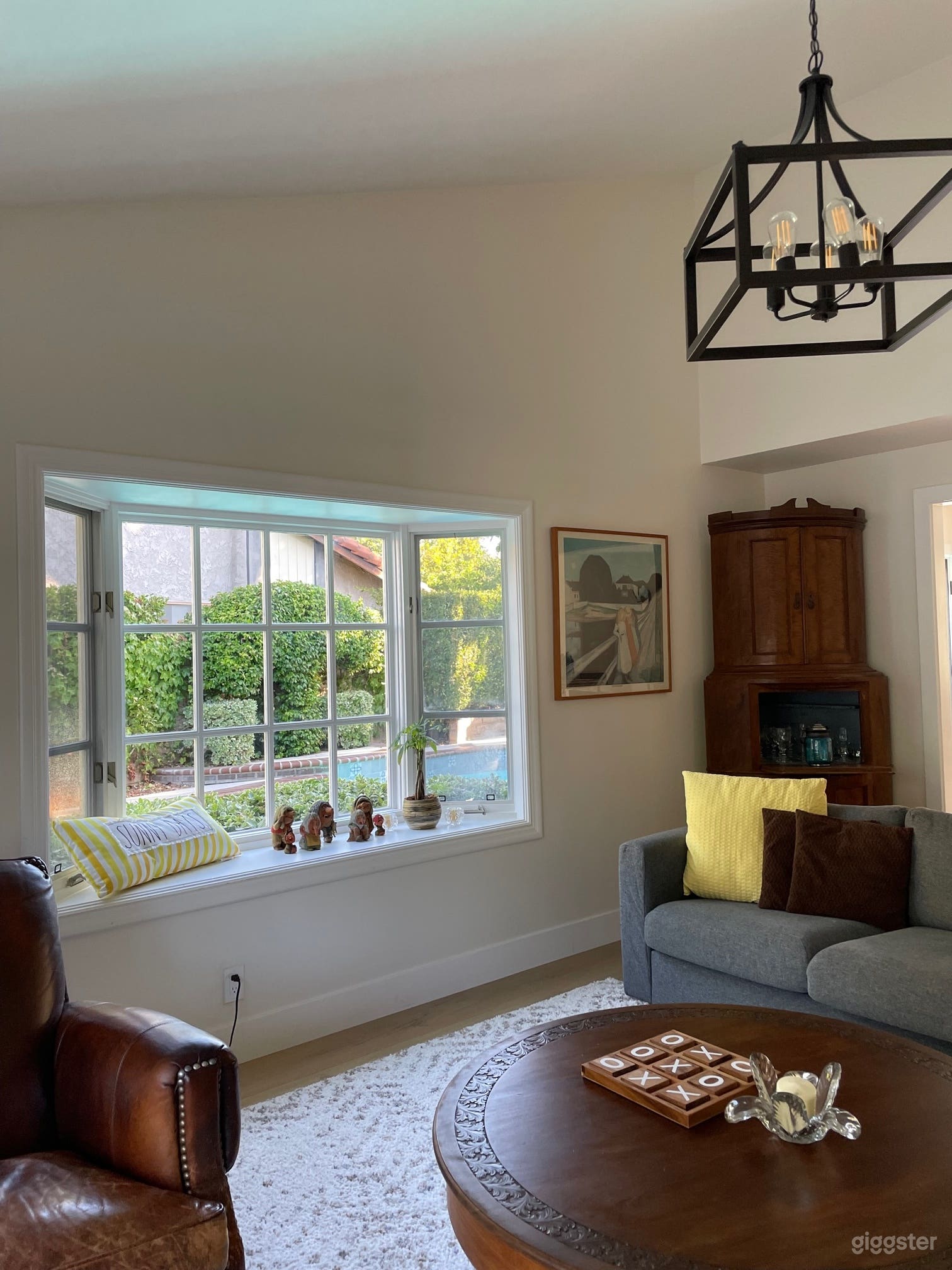 The living room has a bay window that looks out to the pool. 