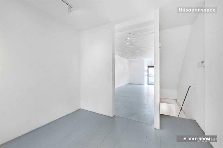  View from the back of the second smaller room showing the front larger room and the staircase down to the basement (washroom and storage room are in basement) 