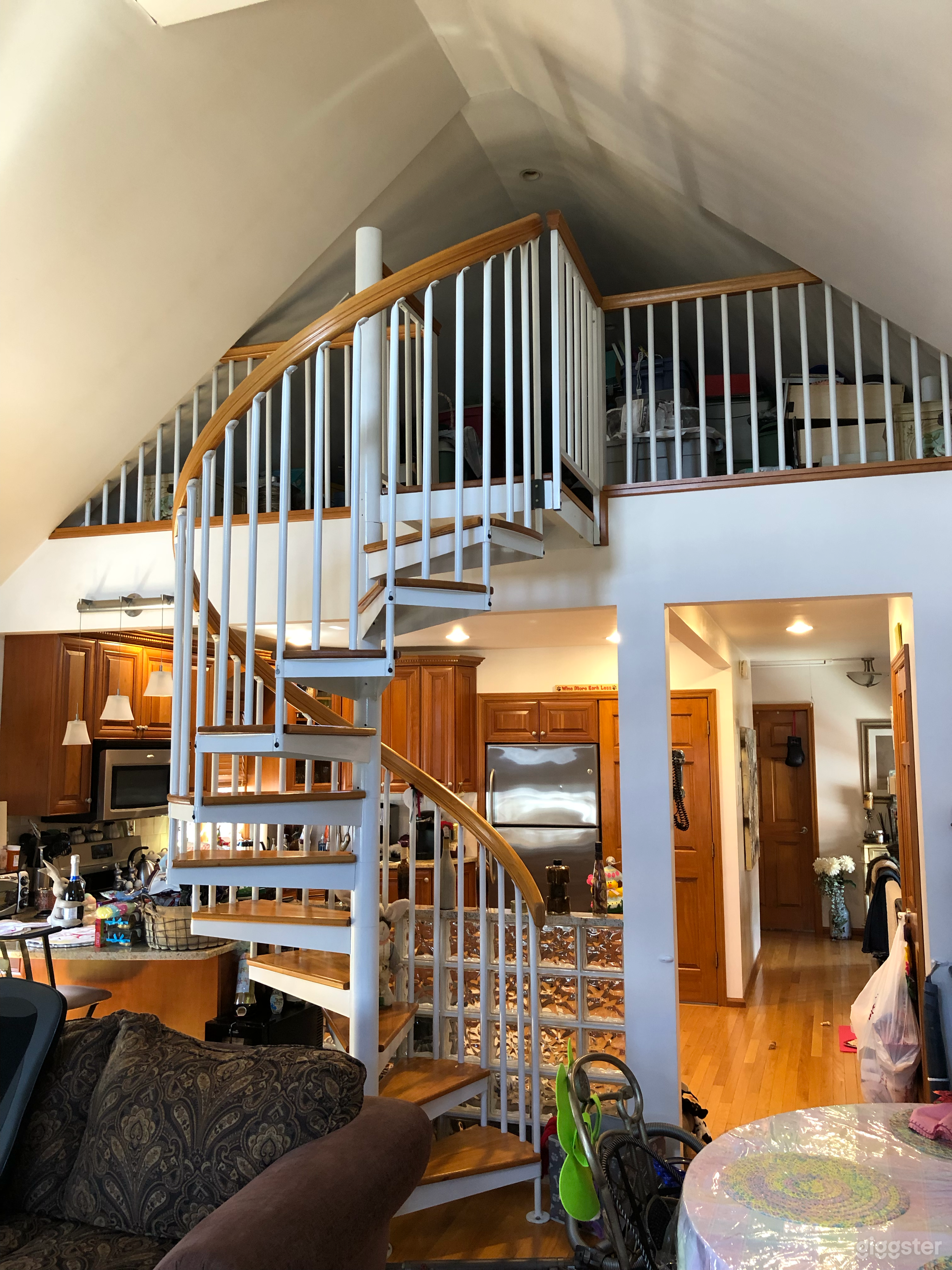 Spiral staircase leading to loft. Open layout kitchen and living room