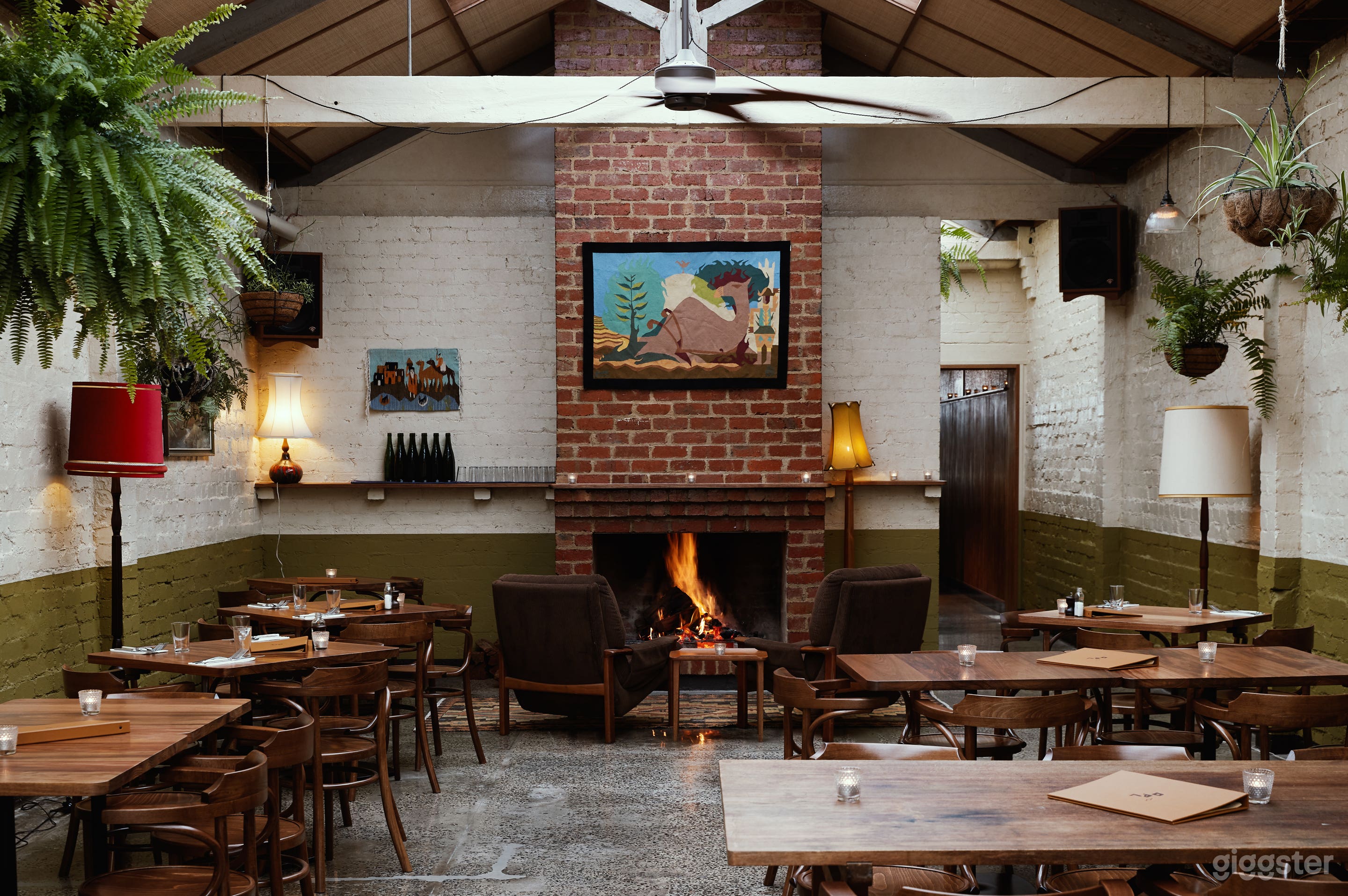 Brick fire place in fern room dining area. Lots of natural light &amp; hanging plants.