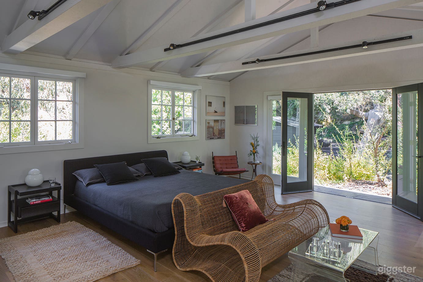 main room with cal king bed, vintage furniture and beautiful private garden views from every window