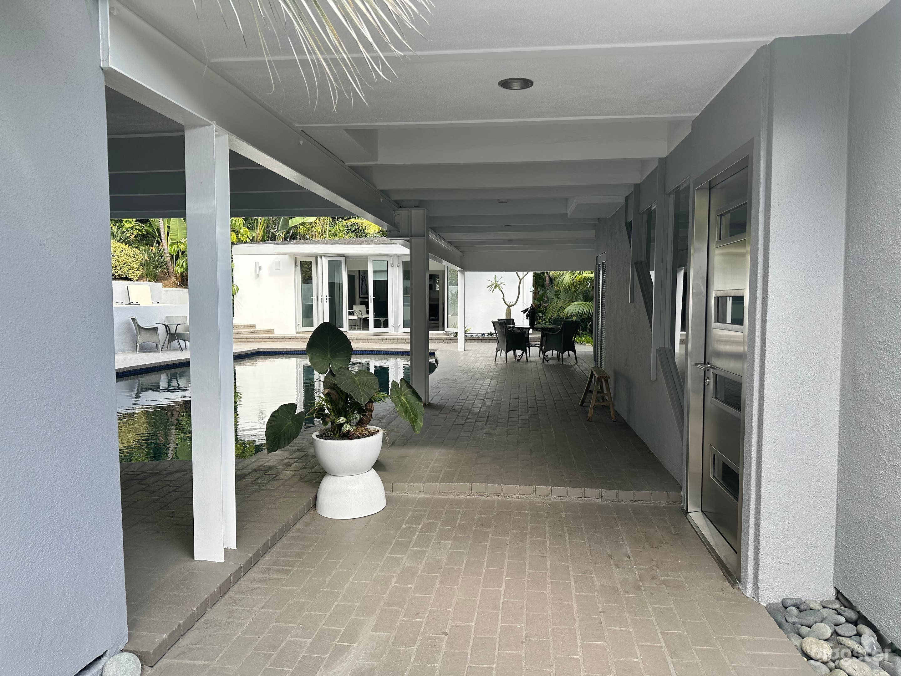 Dramatic pool, main house entrance and cabana view as one enters the steel and glass main entrance doors.